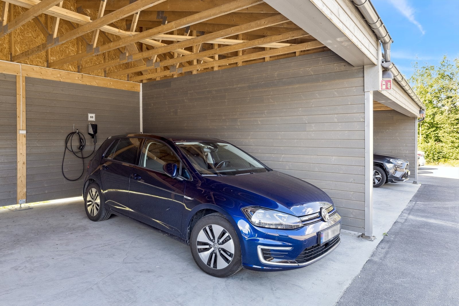 Det medfølgende carport til boligen med montert elbil-lader. Galleribilde