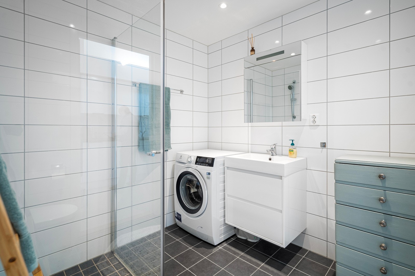Moderne baderomsinnredning og tilhørende speil - badet er flislagt på gulv og vegger Galleribilde