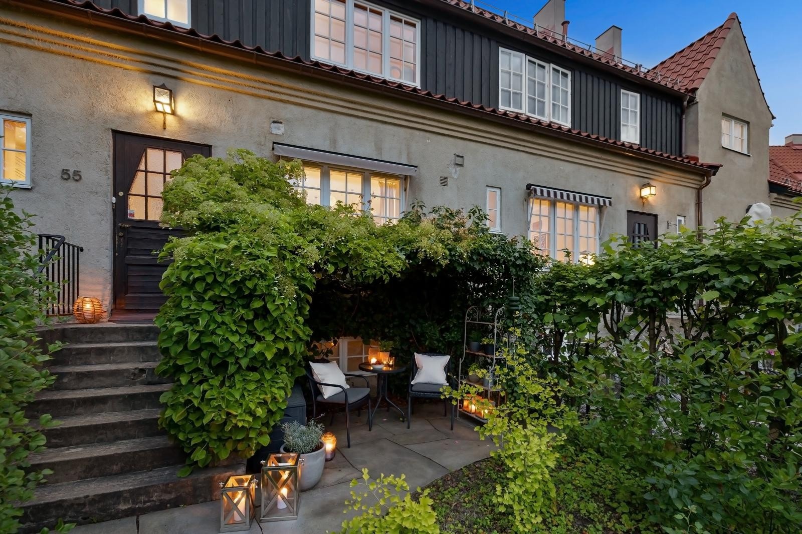 Foran huset ligger en frodig og solrik hage med gjerde og port ut mot bilfri internvei. Galleribilde