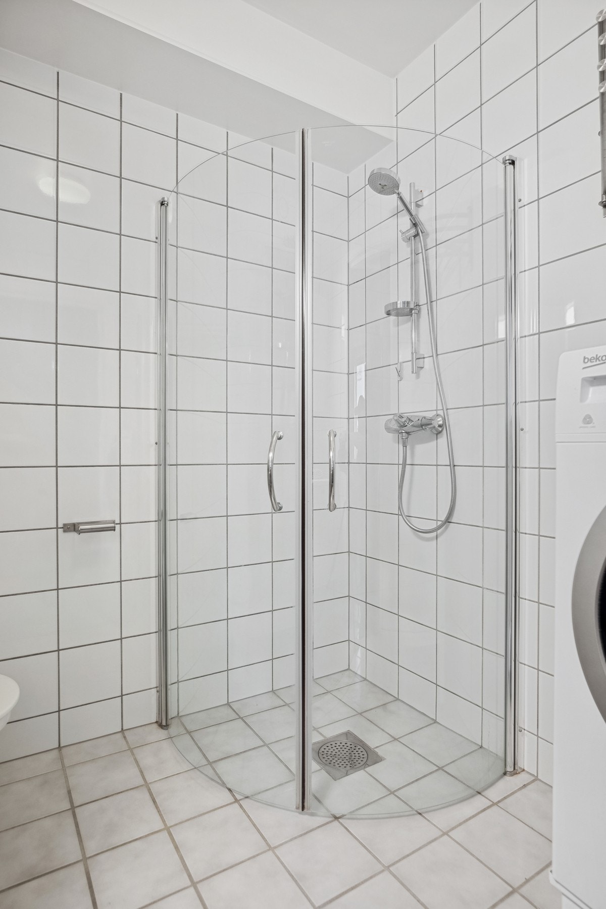 Praktiske innfellbare dusjdører som bidrar til å en romsligere opplevelse av badet. Galleribilde