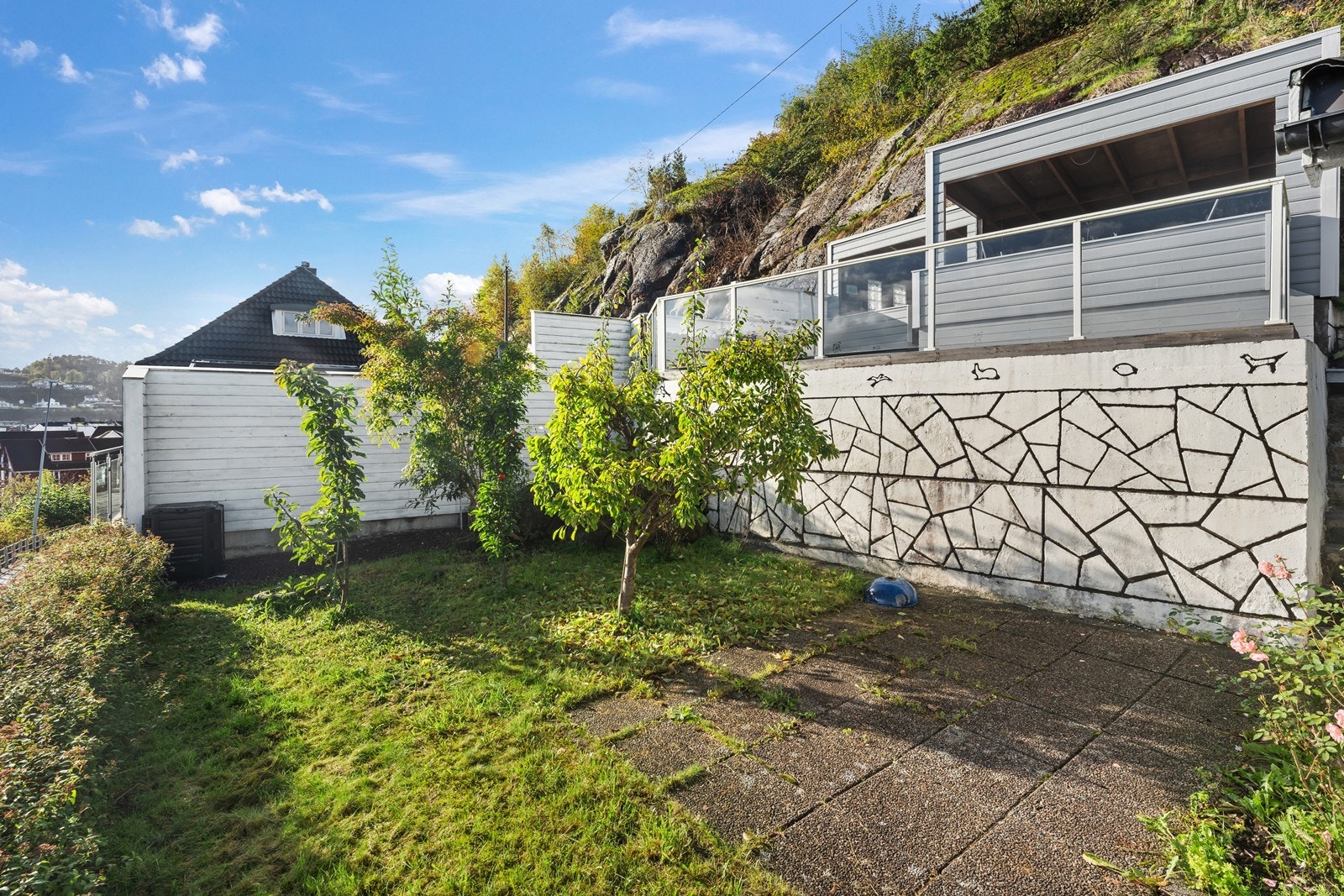 Koselig hage med frukttrær og større platting med hagestue. Galleribilde