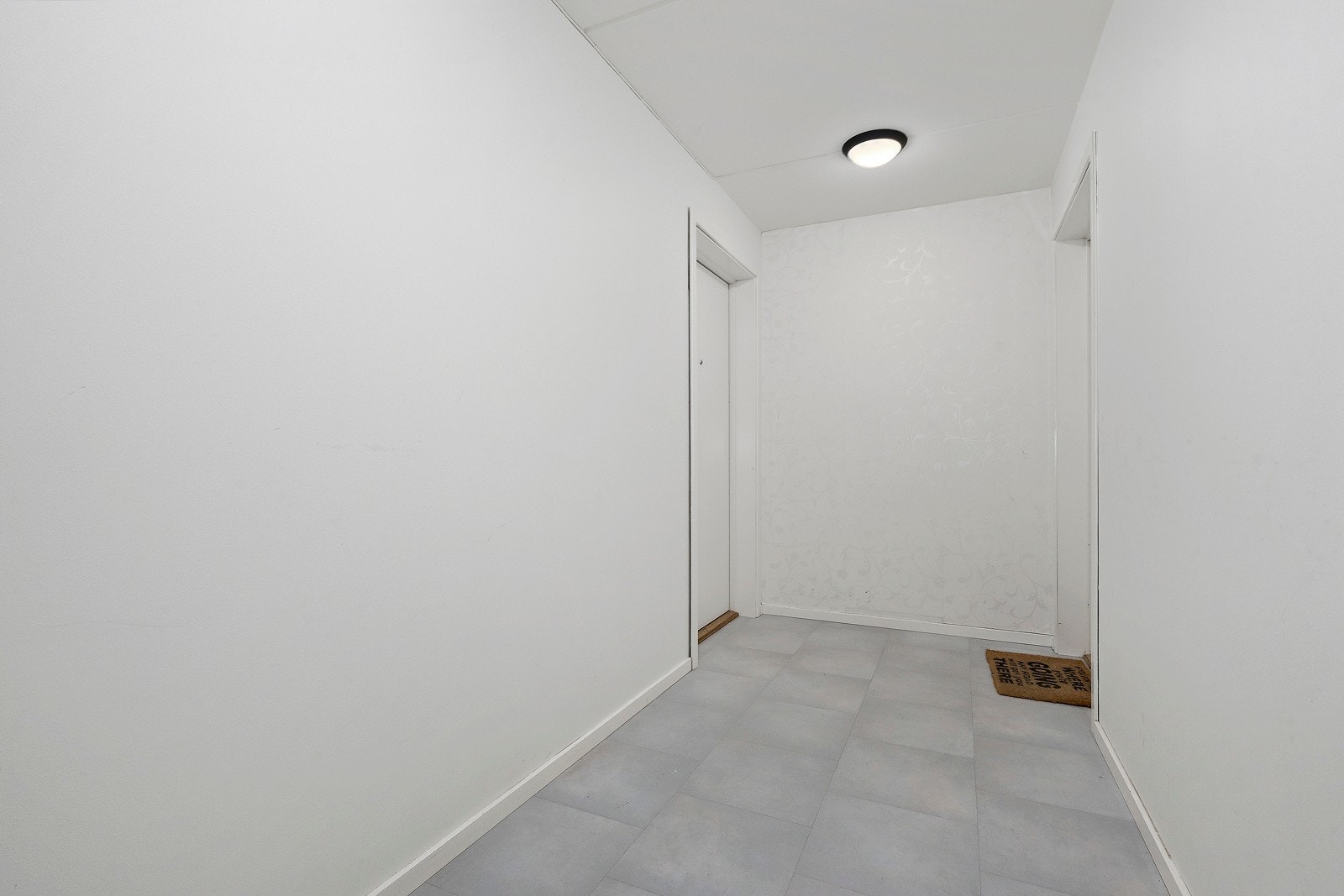 Adkomst via svalgangen og inn i et felles vindfang som deles med denne leiligheten og naboleiligheten Galleribilde