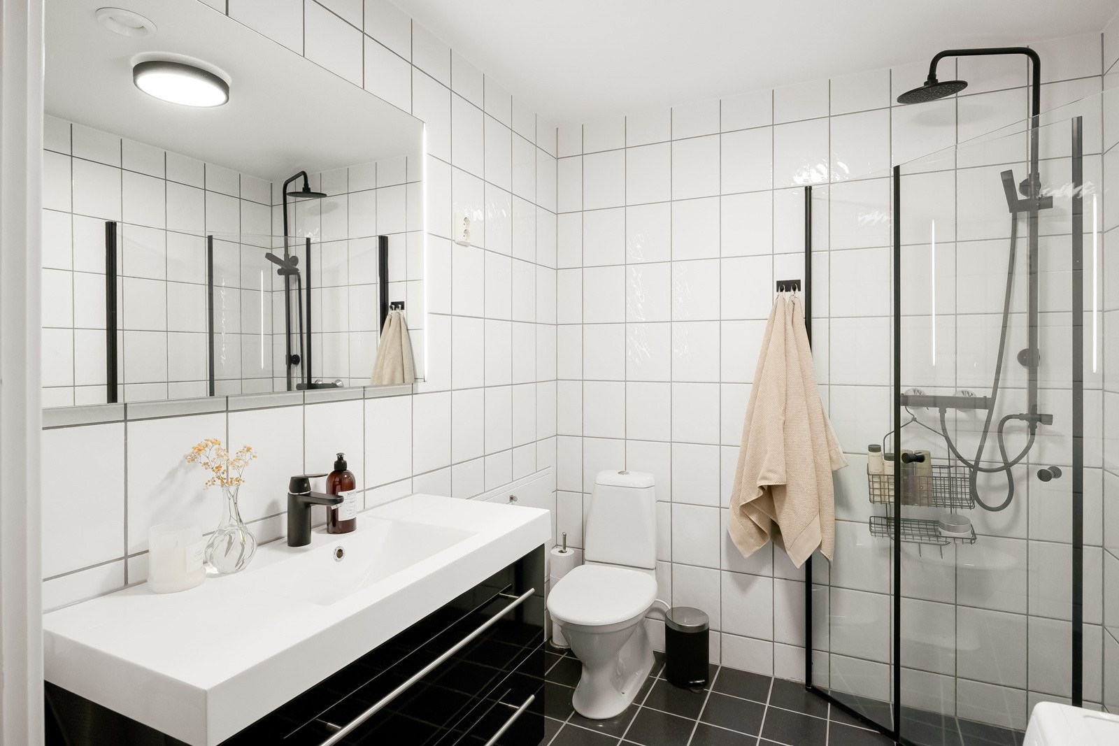 Badet er utstyrt med en romslig baderomsinnredning, toalett, dusjhjørne med innfellbare dører og opplegg for vaskemaskin. Galleribilde