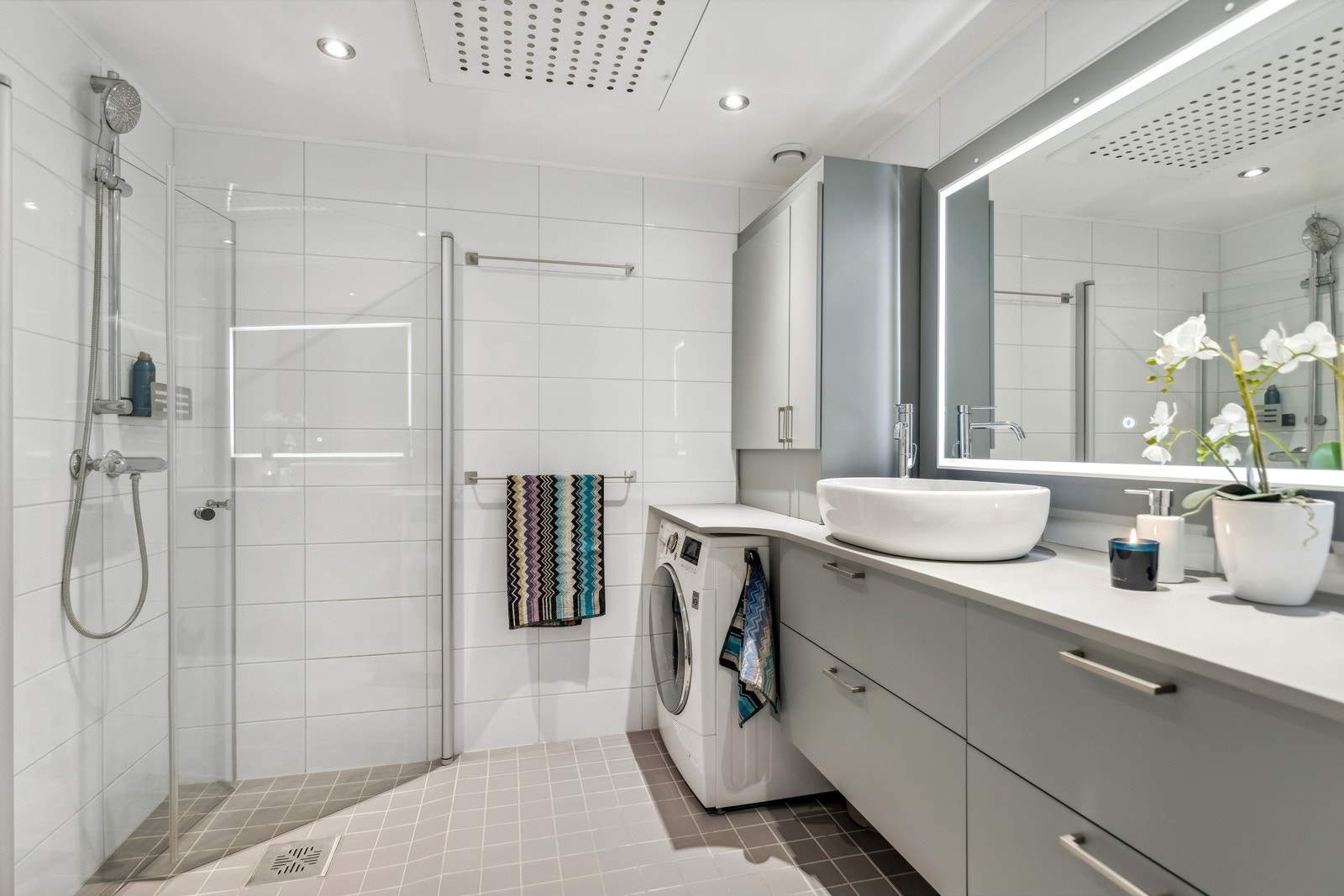 Badet har gulvvarme. Vegghengt toalett, dusjhjørne med innfellbare dører og opplegg for vaskemaskin. Galleribilde