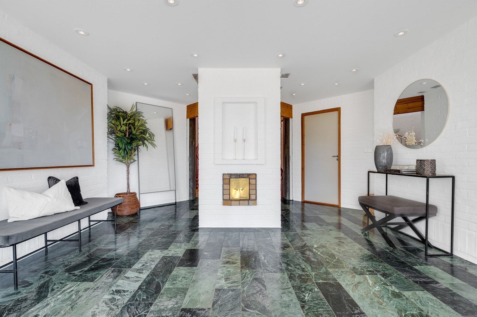 Romslig hall med varmekabler og plassmurt kombipeis med innsats og parafinbrenner. Galleribilde