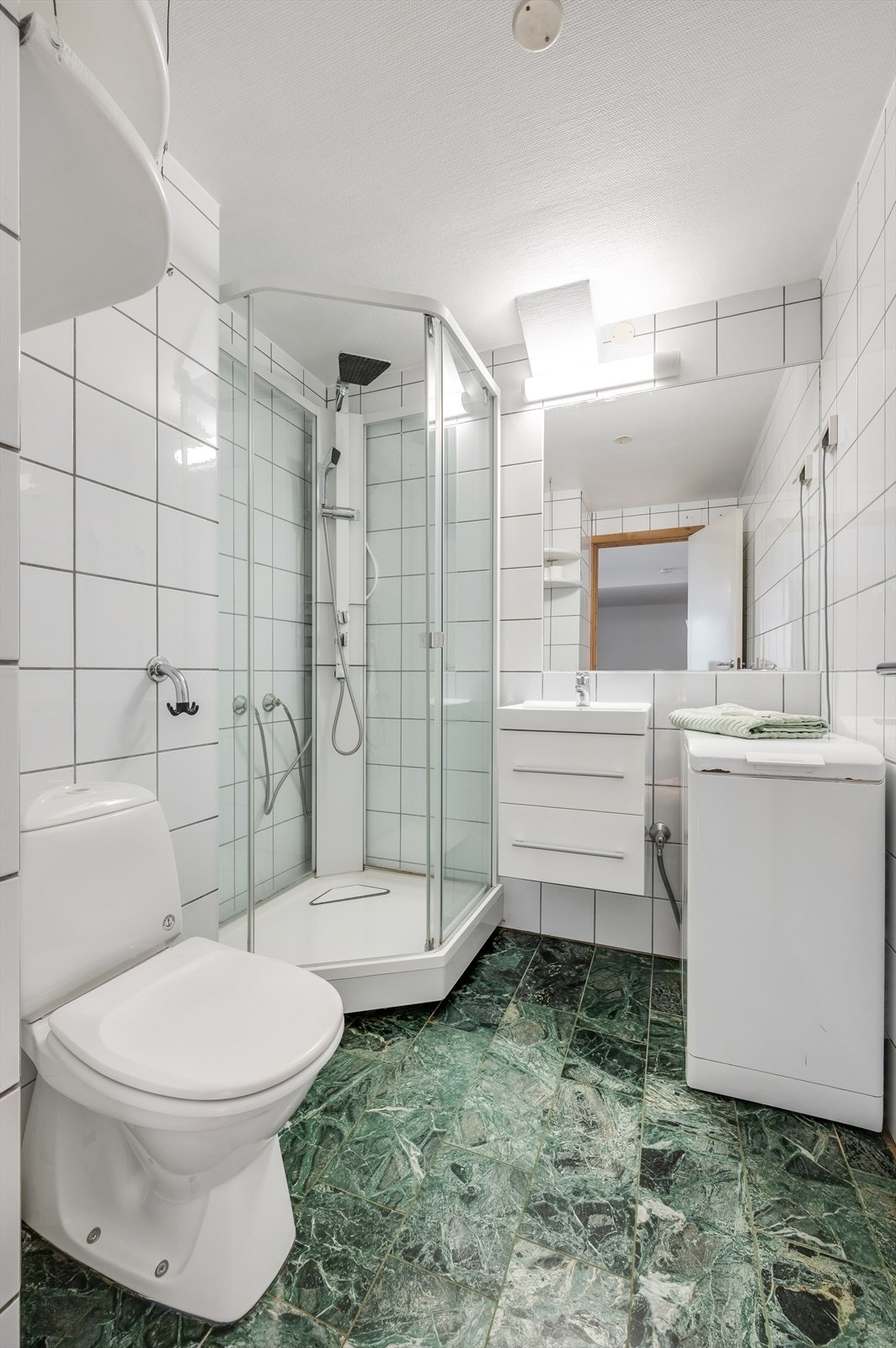 Innenfor dette soverommet er det eget flislagt dusjbad med toalett og opplegg for vaskemaskin. Galleribilde