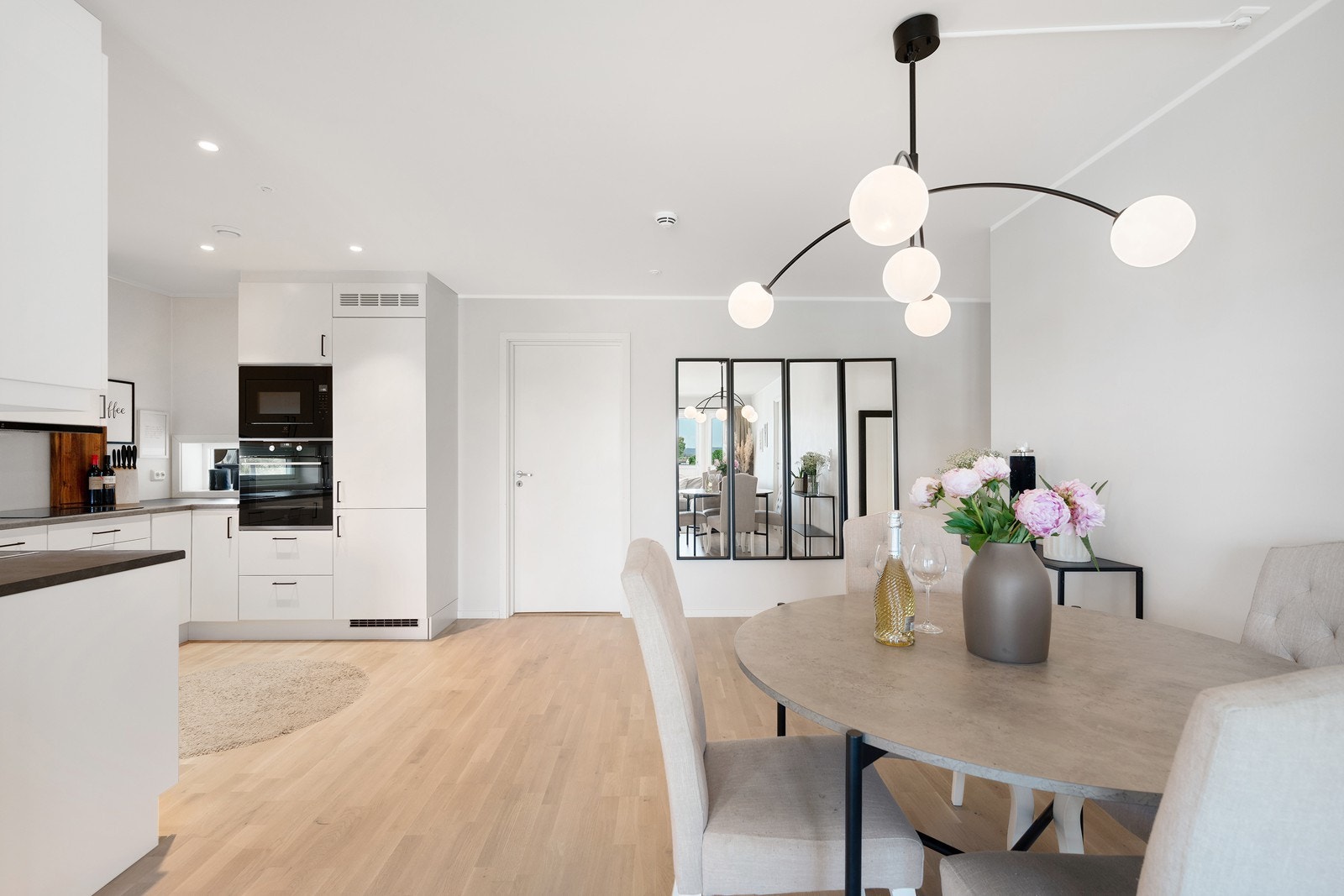 Kjøkkenet ligger i åpen løsning og er holdt i et flott, moderne design med takhøy innredning, downlights og vindu mellom overskap og benkeplaten. Galleribilde