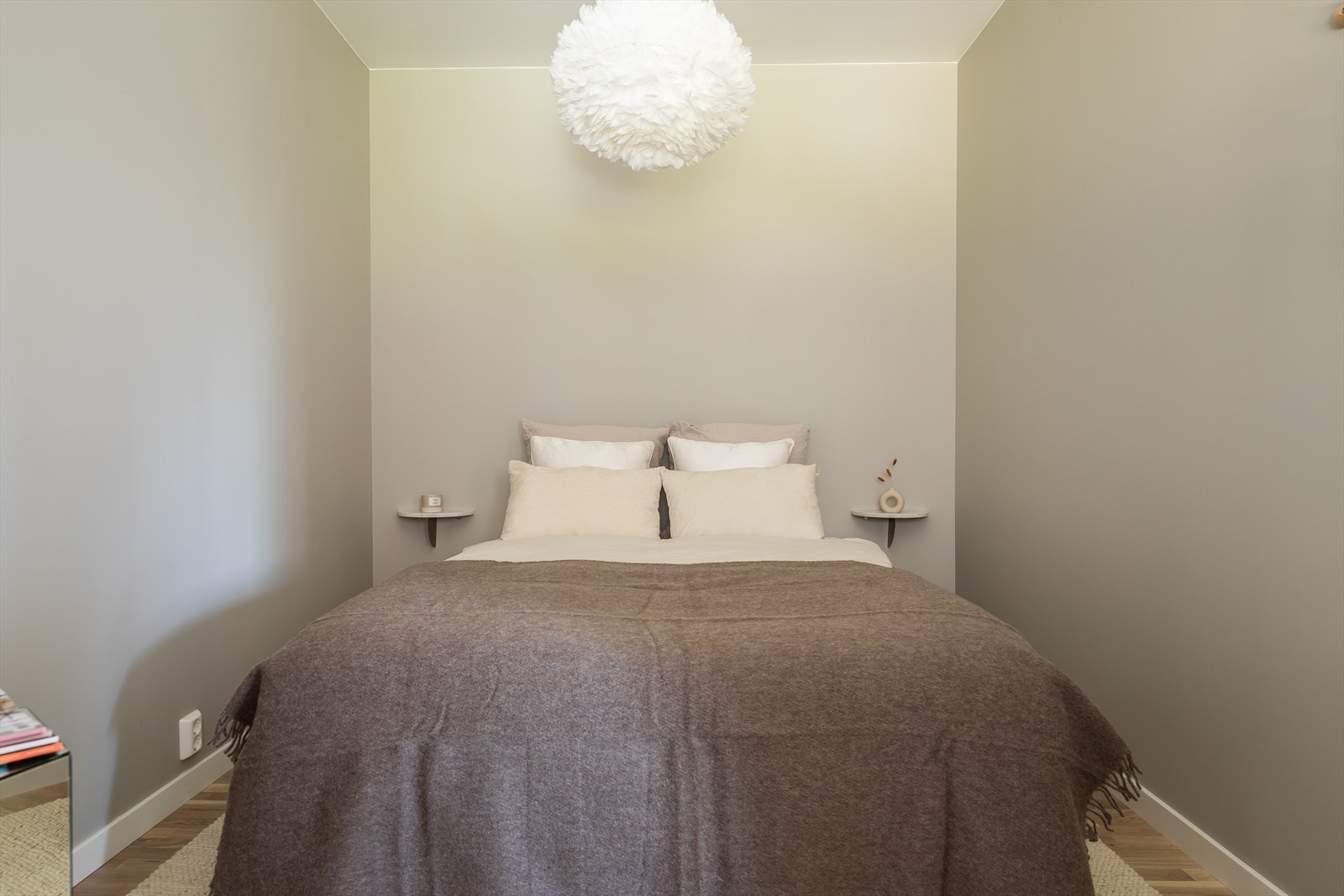 Flott soverom med plass til stor dobbeltseng med tilhørende nattbord på begge sider Galleribilde