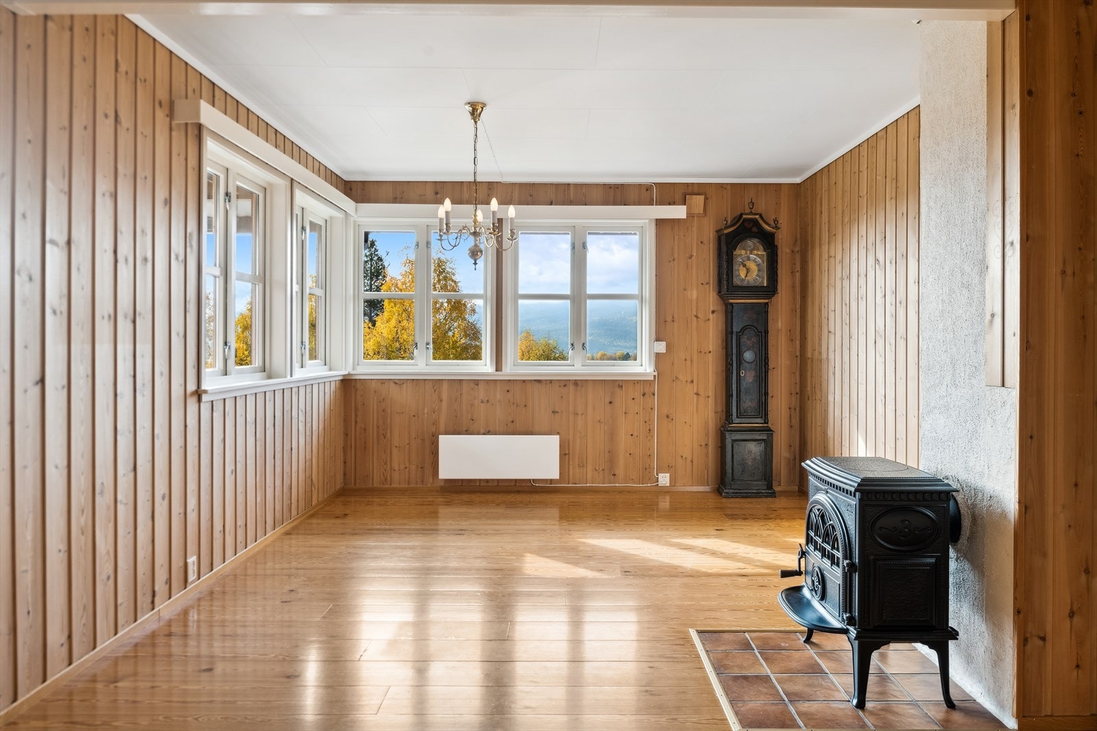 Stuen har store vindusflater med god utsikt og en peisovn som gir god varme på kaldere høst- og vinterdager. Galleribilde