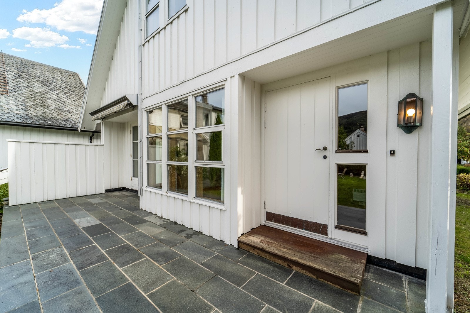Uteområde belagt med skiferheller. Eiendommen har gode solforhold. Galleribilde