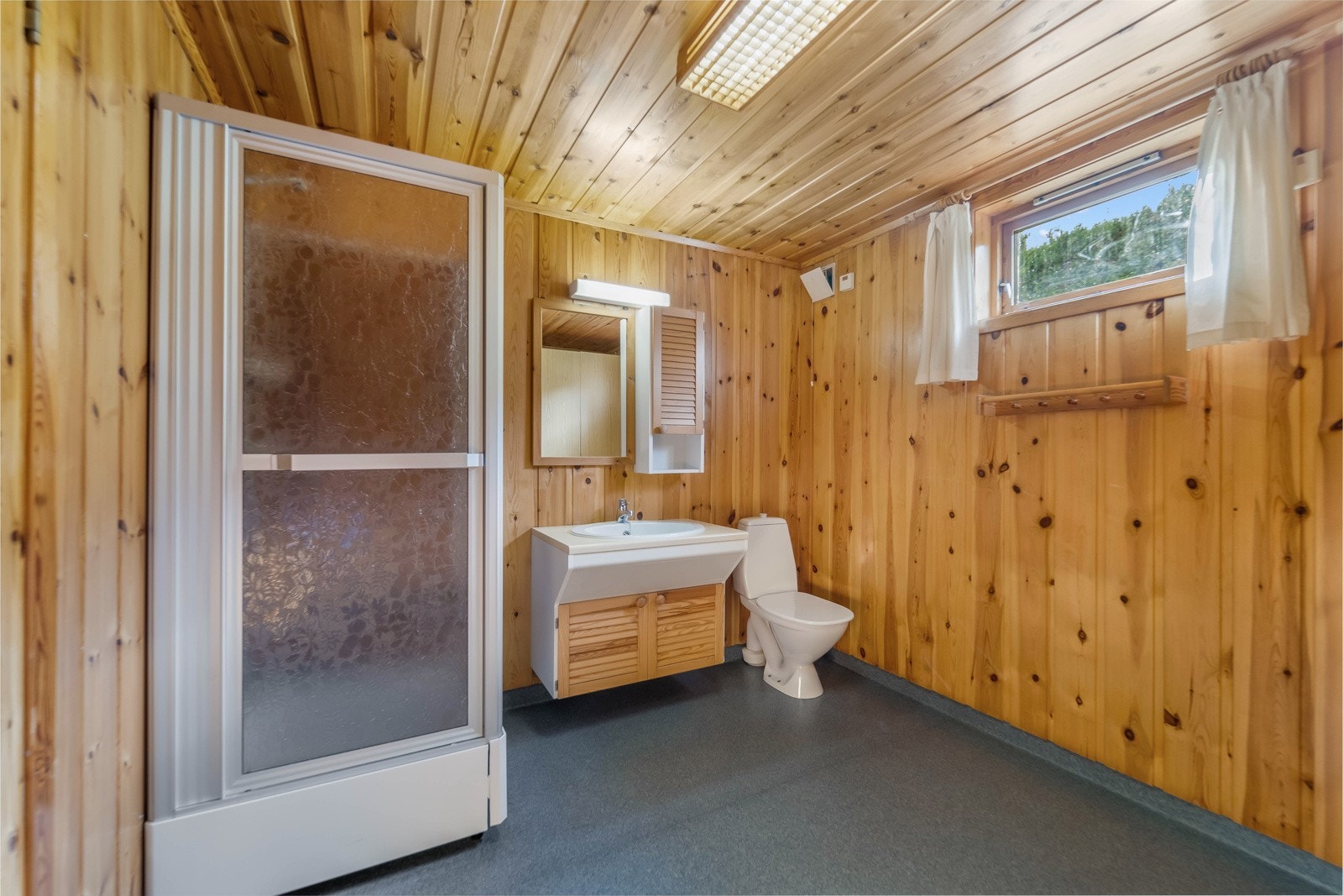 Badet i kjelleretasjen har belegg med varmekabler i gulvet og panel på veggene. Galleribilde