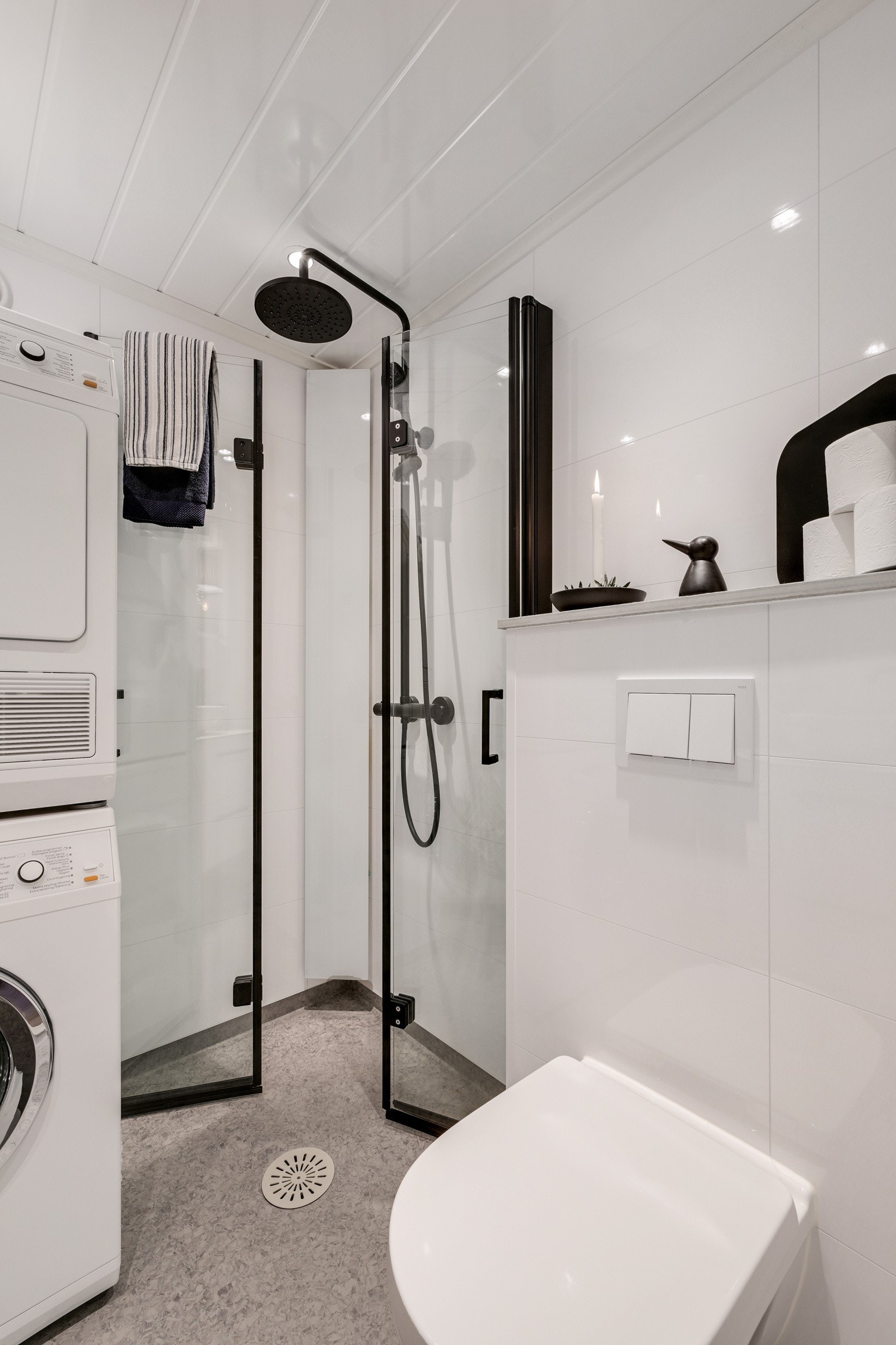 Badet er innredet med speilskap med lys, vegghengt toalett, dusjhjørne, opplegg for vaskemaskin og servant med baderomsinnredning. Galleribilde