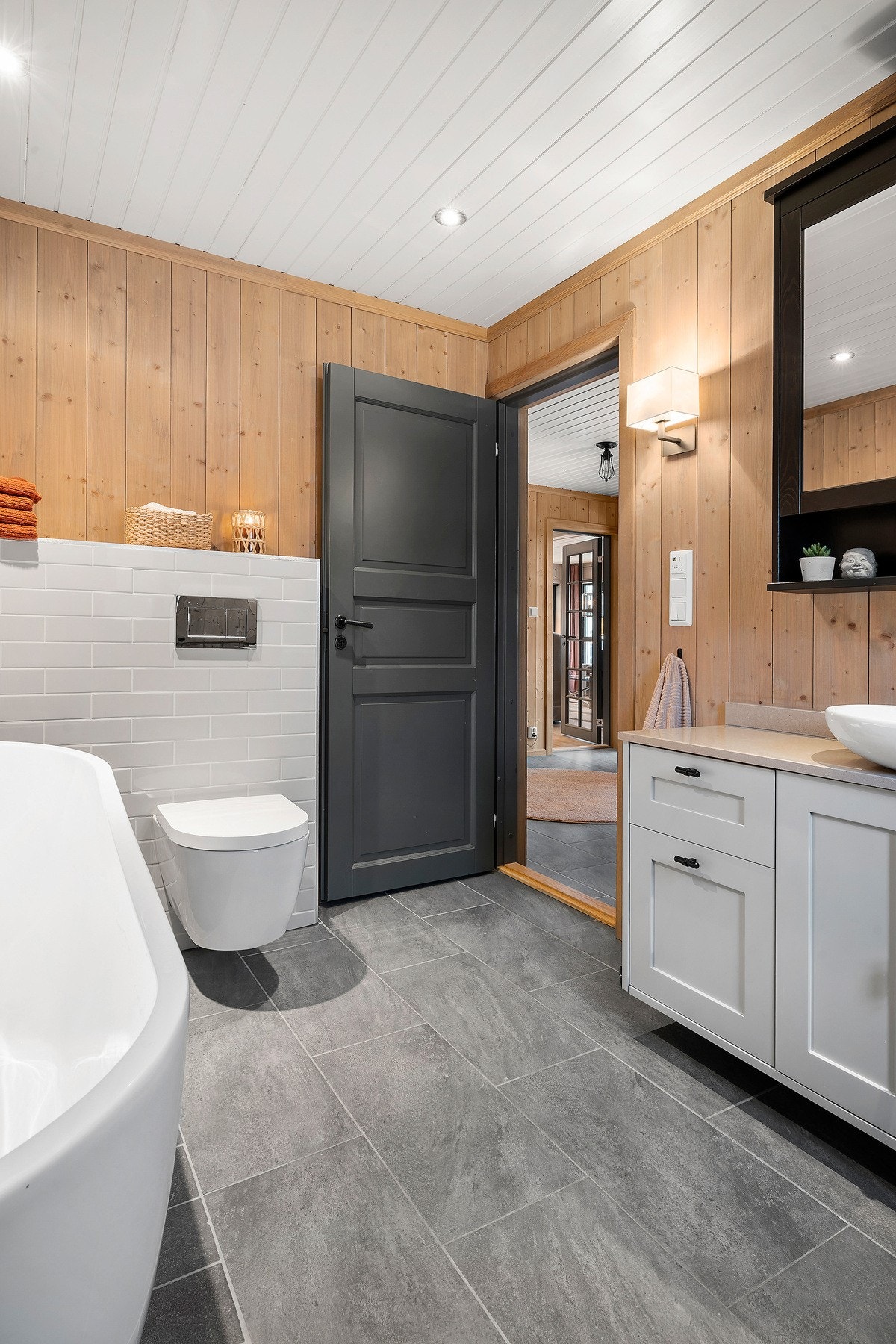 Videre er badet utstyrt med toalett, flott skapinnredning med servant og speil. Galleribilde