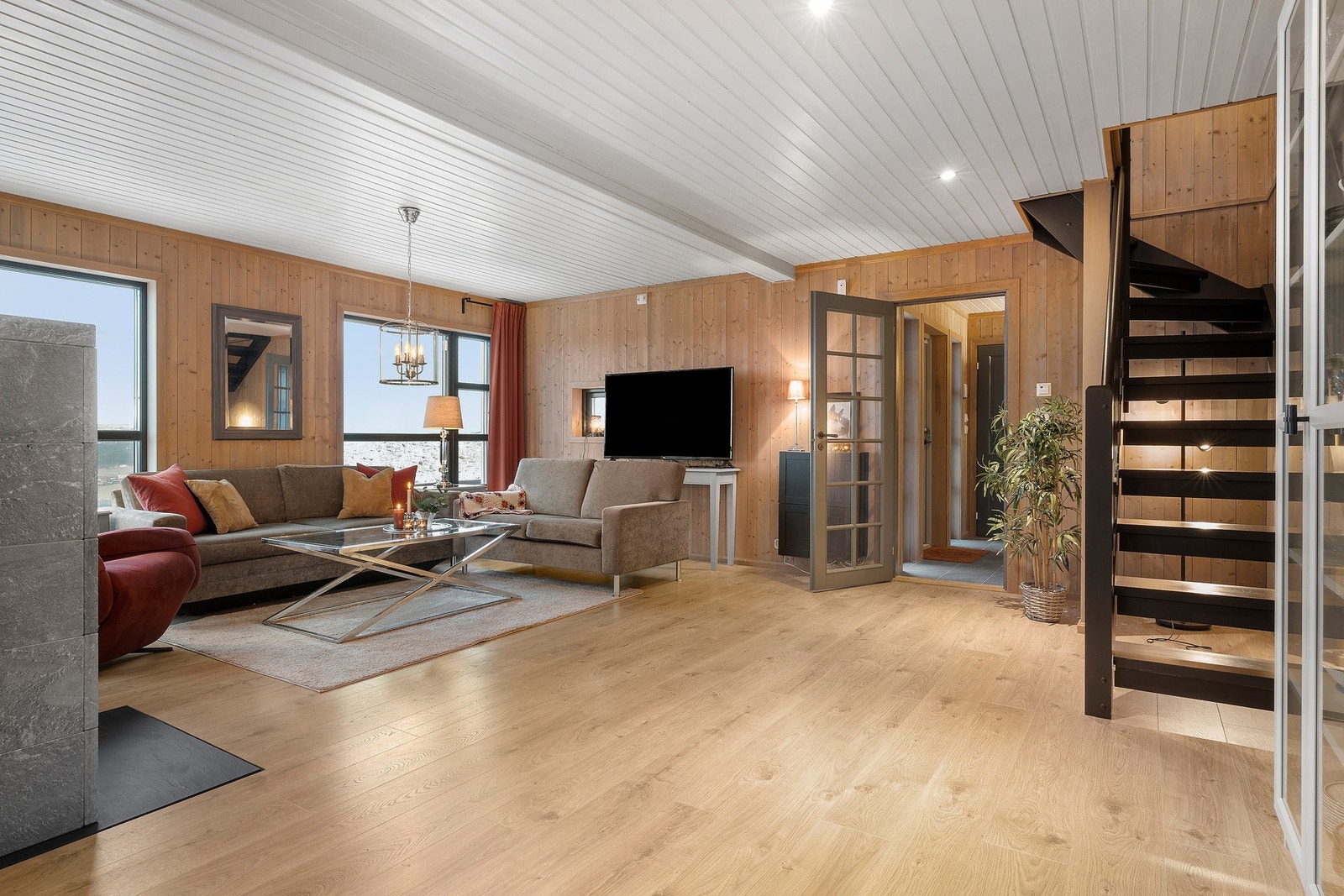 Det herlige oppholdsrommet har høytrykkslaminat fra Kronotex, panel på vegger. Panel i himling med downlights. Galleribilde