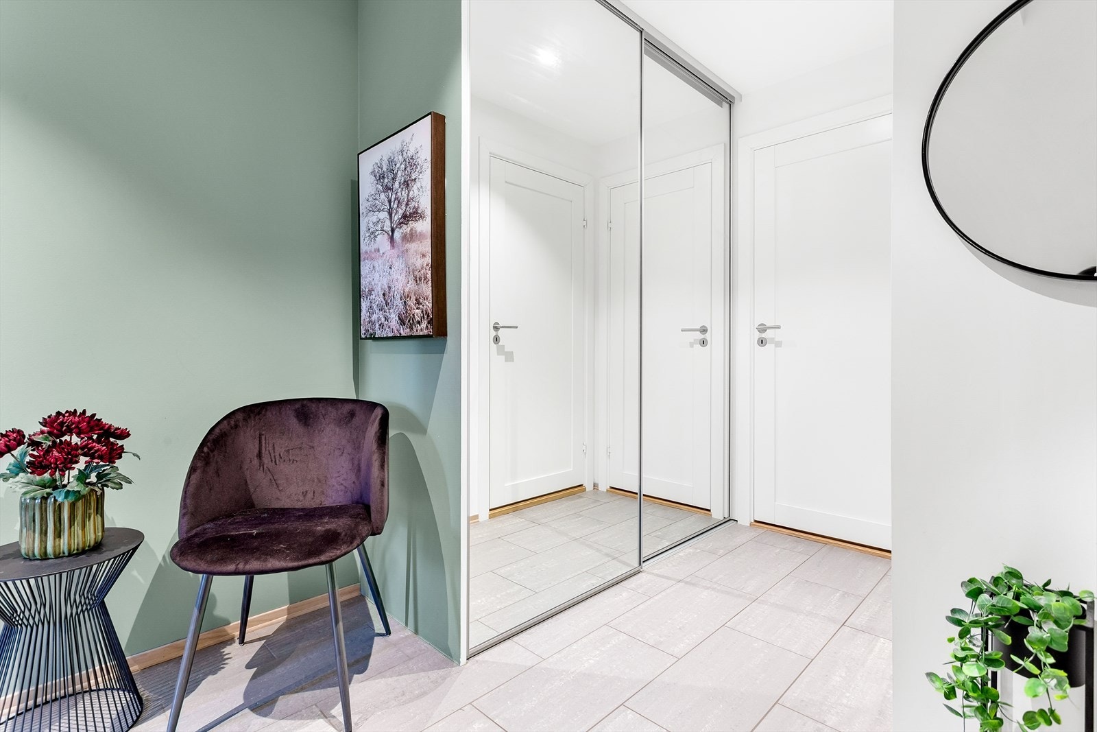Innbydende entré med god plass til oppbevaring av sko og yttertøy i en praktisk skyvedørsgarderobe med speilfronter. Galleribilde