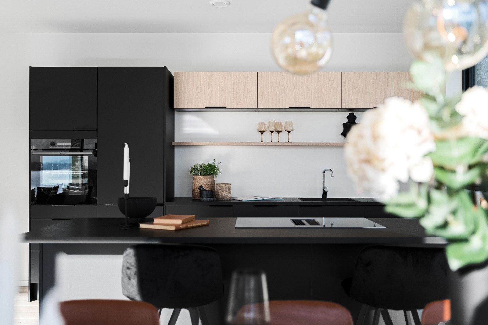 Moderne kjøkkeninnredning med integrert stekeovn, koketopp med integrert ventilator, oppvaskmaskin og kjøleskap. Galleribilde