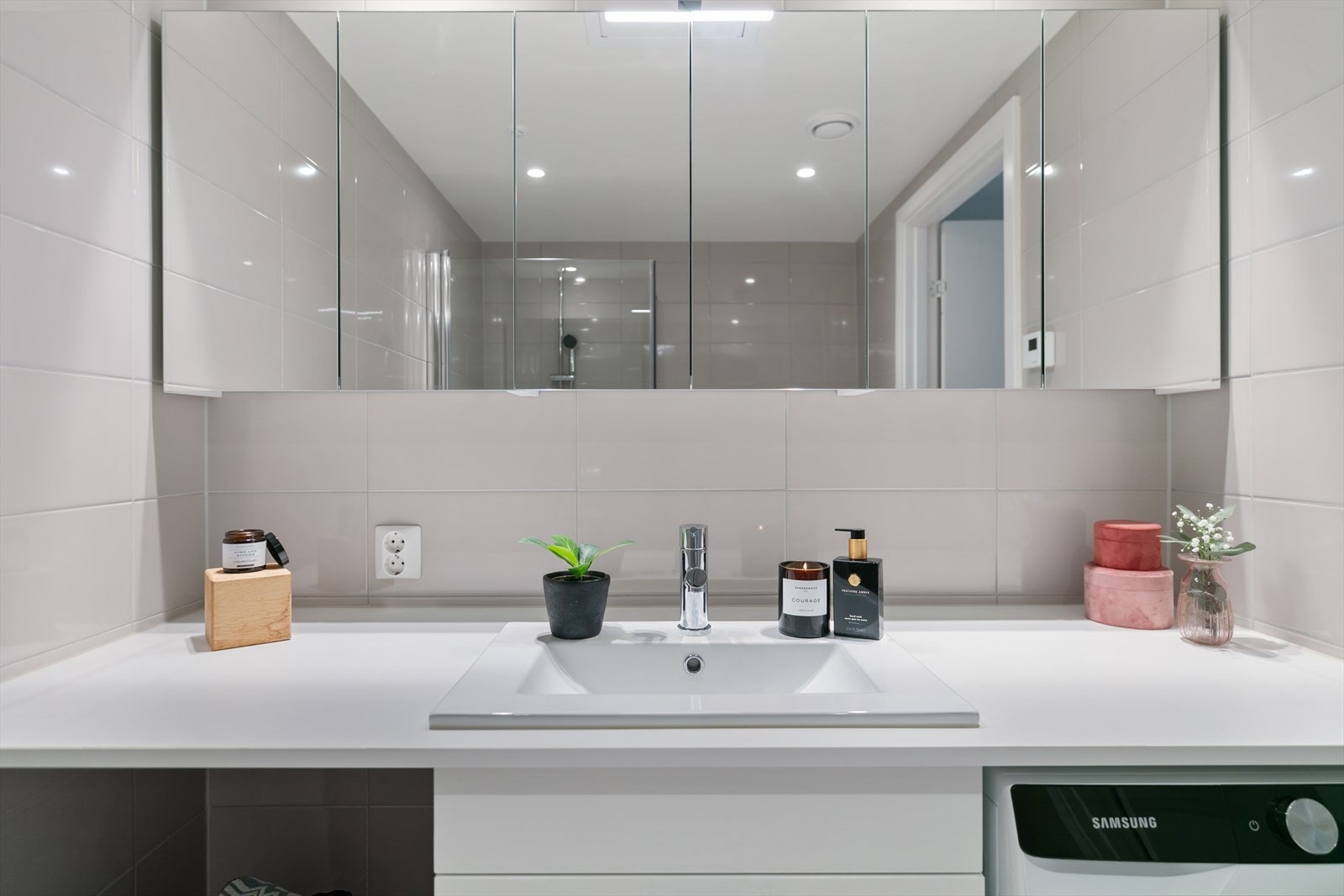 Av utstyr er det lys baderomsinnredning med nedfelt servant, overskap med speilfronter og belysning, vegghengt toalett, dusjhjørne med glassdører og opplegg for vaskemaskin Galleribilde