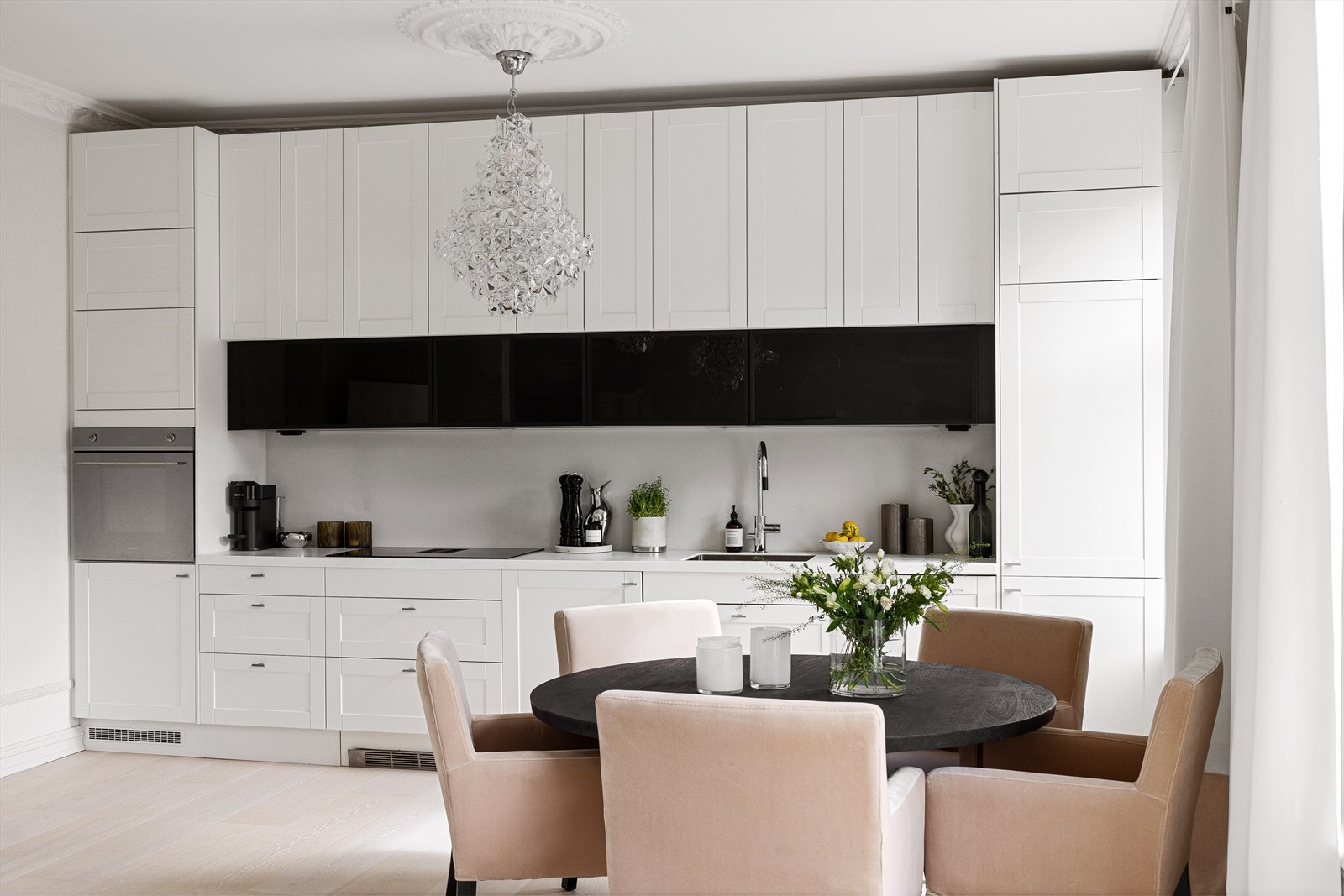 Et lekkert kjøkken med profilerte fronter og integrerte hvitevarer som stekeovn, platetopp med integrert vifte, vaskemaskin, oppvaskmaskin og kjøl- / fryseskap Galleribilde