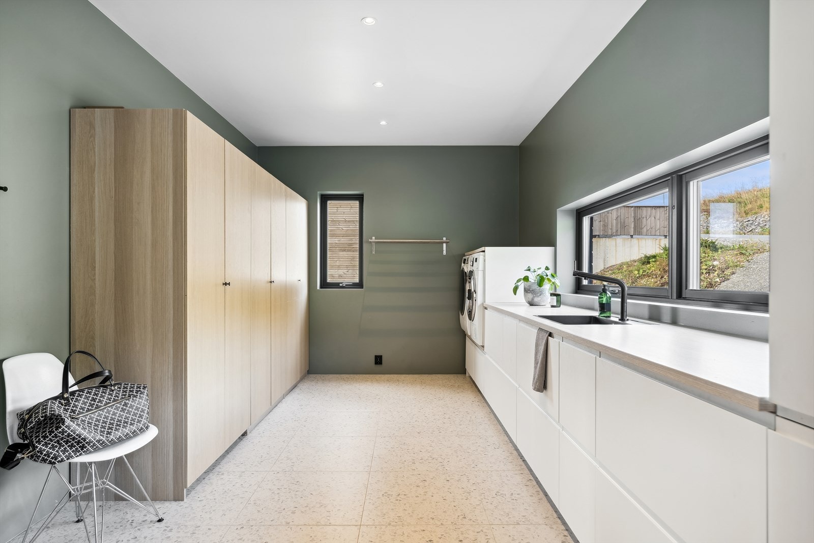 Et eget vaskerom i andre etasje forenkler hverdagen, innredet med stort garderobeskap og en praktisk skapinnredning. Galleribilde