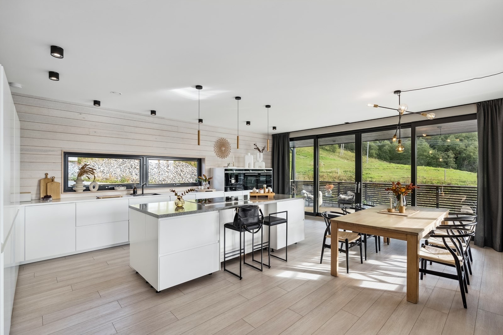 En stor skyvedør i glass fører ut til den flotte terrassen, og om sommeren kan man viske bort skille mellom inne og ute. Galleribilde