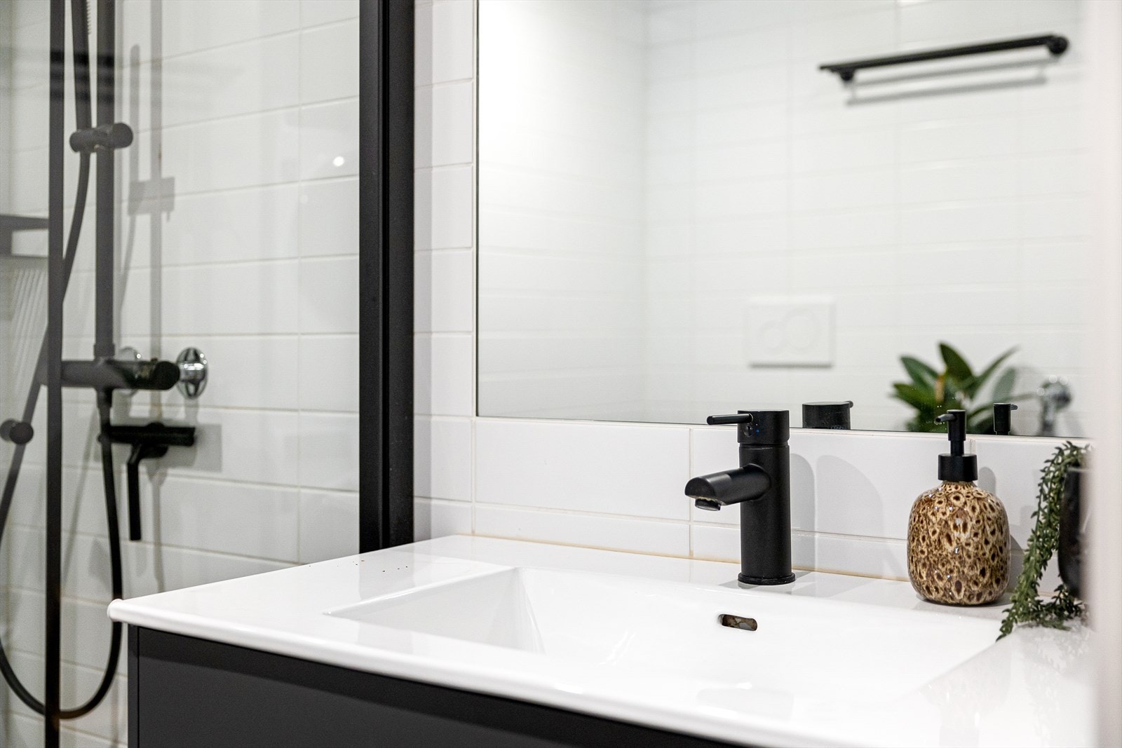 Badet er innredet med vegghengt klosett, servant nedfelt i innredning, speil m/lys og dusjhjørne med svingbare glassdører. Galleribilde