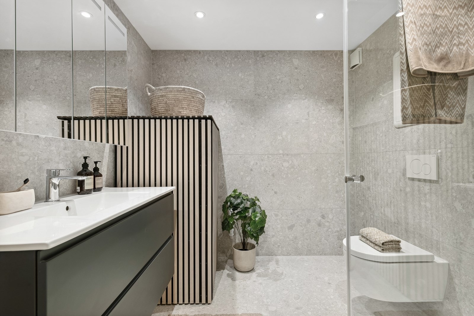 Baderom nummer to bærer også preg av luksus med sine store Mirage Norr fliser, samt stilren baderomsinnredning Galleribilde