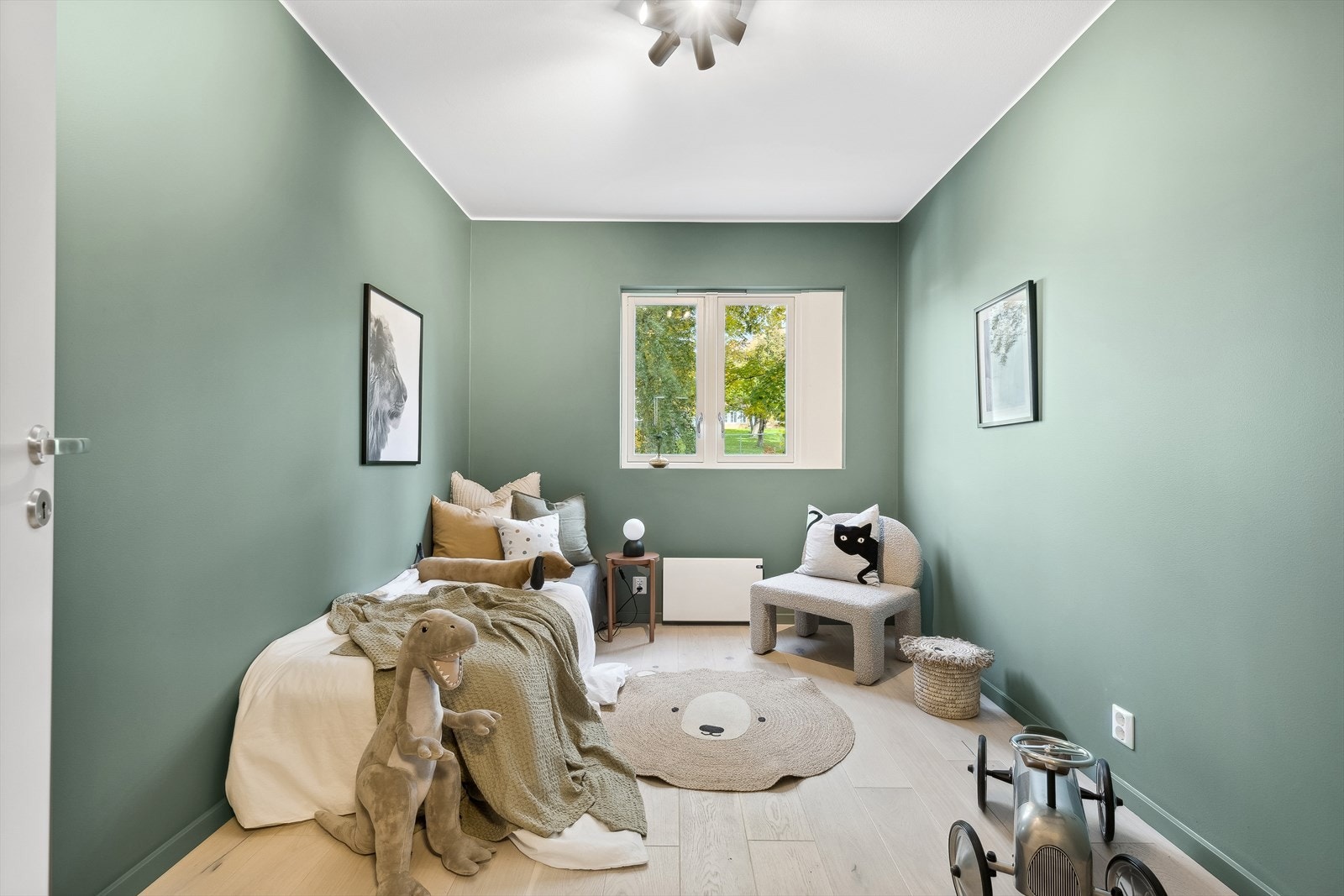 Veggflatene er malt opp i en smakfull grønntone, og gulvflatene består av stilren 1-stavs eikeparkett som er gjennomgående for hele leiligheten Galleribilde