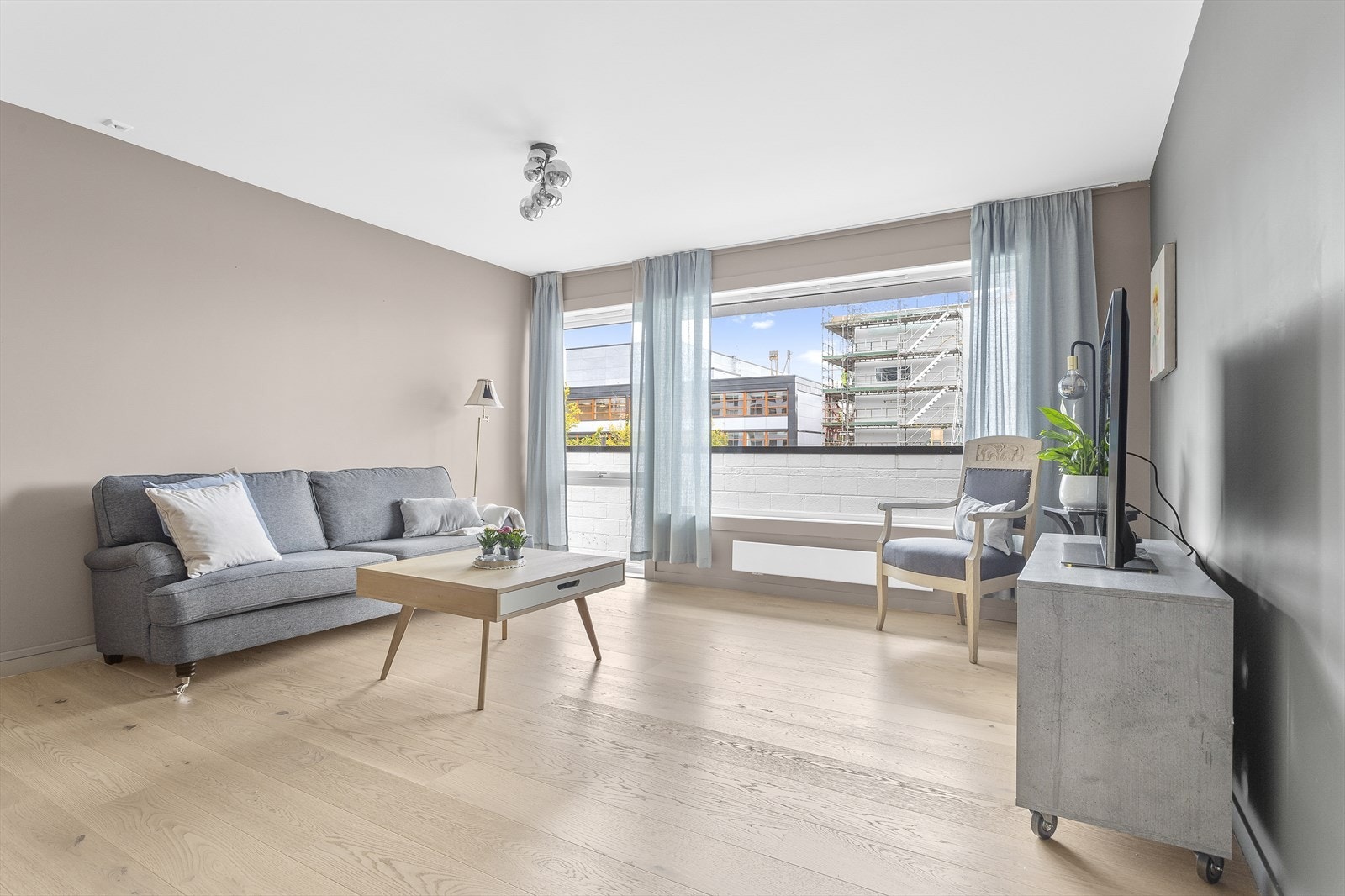 Veggene som er malt i grått og beige harmonerer med de flotte parkettgulvene. Galleribilde