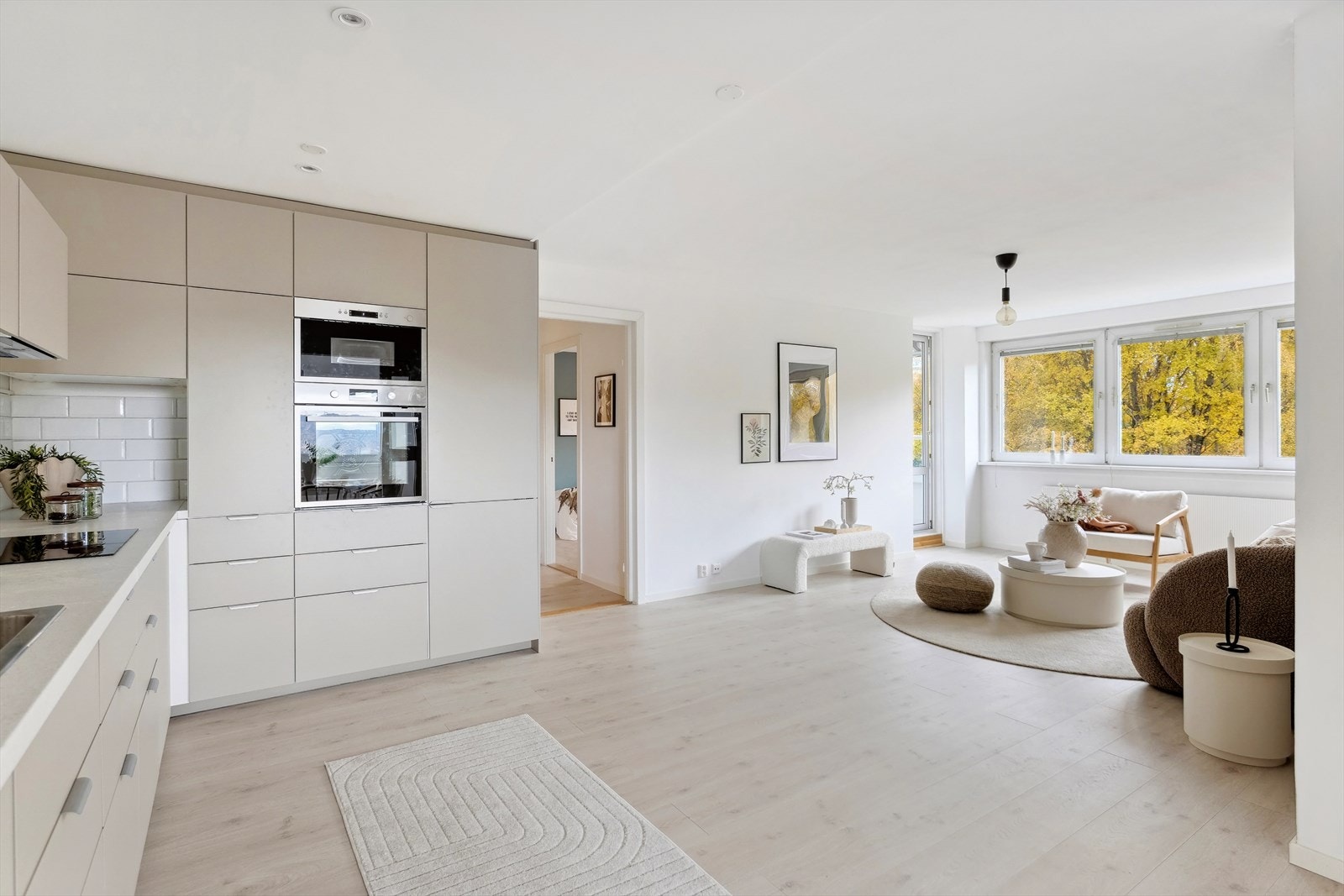 Leiligheten har en åpen og moderne stue-/kjøkkenløsning. Her er det også plass til spisebord. Galleribilde