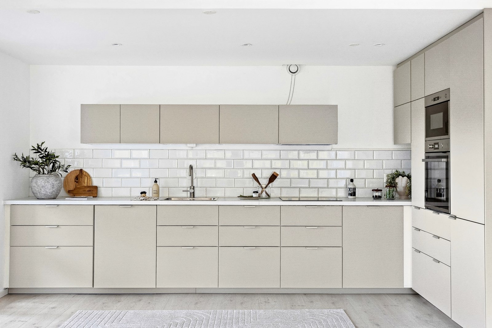 Smakfullt og lekkert kjøkken med glatte fronter i beigetonet utførelse og laminert benkeplate med nedfelt oppvaskkum. Galleribilde