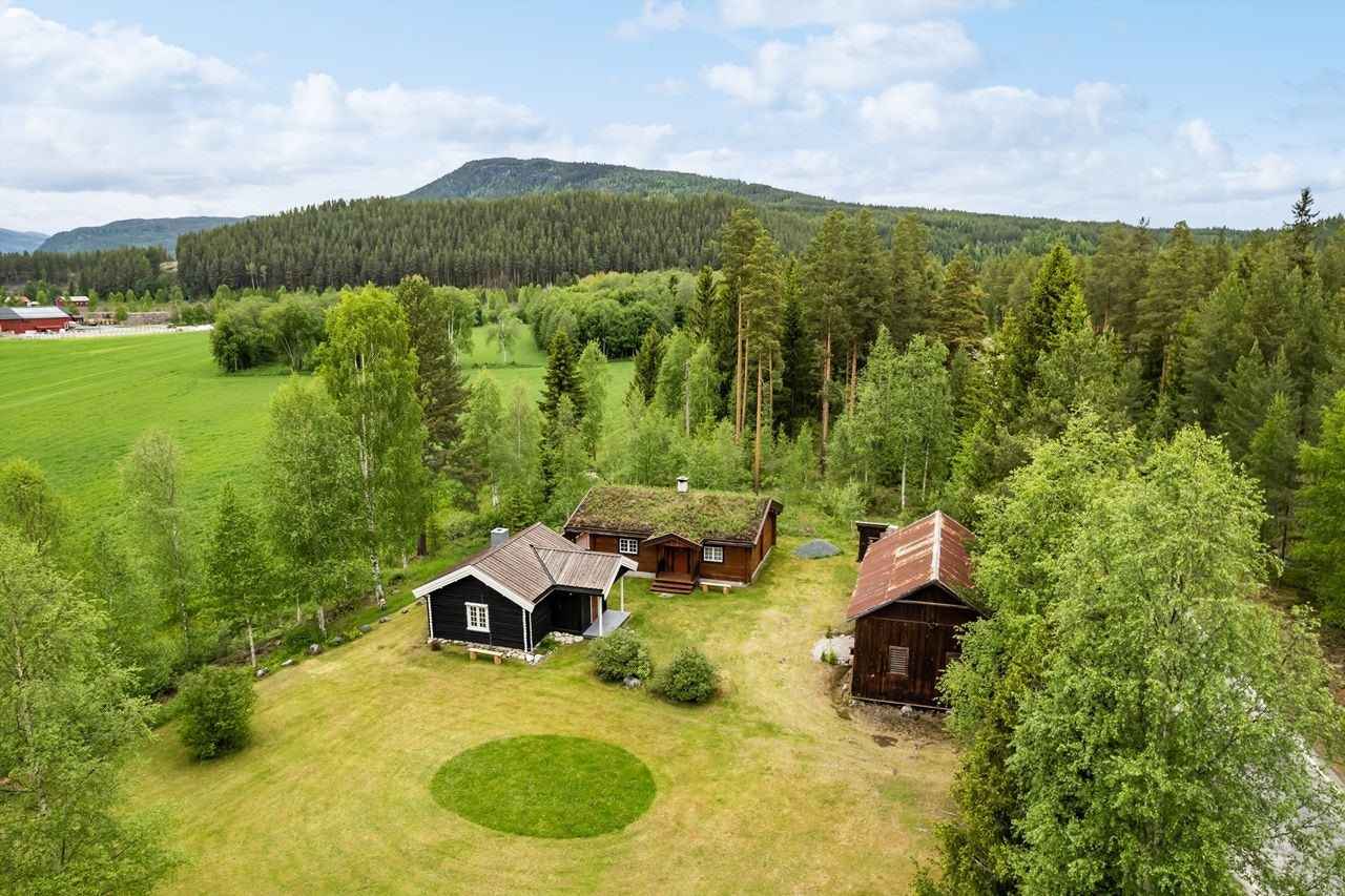 Velkommen til et koselig hyttetun i Atnaveien 276 på Koppang! Fullt møblert sekundærbolig med strømstøtte. Eiendommen består av to hytter og låve. Galleribilde