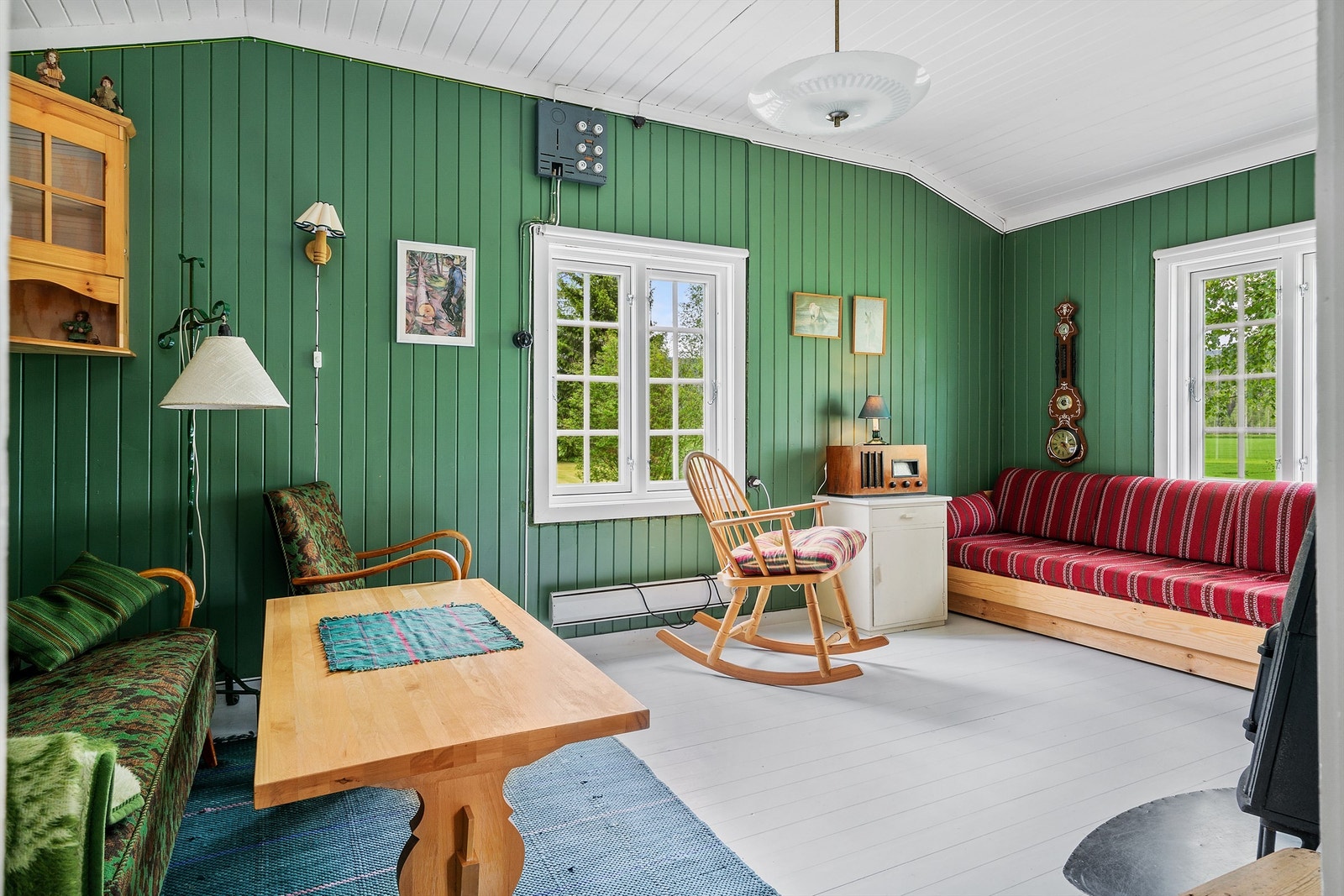 Stuen har grønnmalt panel på veggene, gråmalt tregulv og lysmalt panel i himling. Rommet er romslig med god plass til det man skulle ønske av møblement. Galleribilde