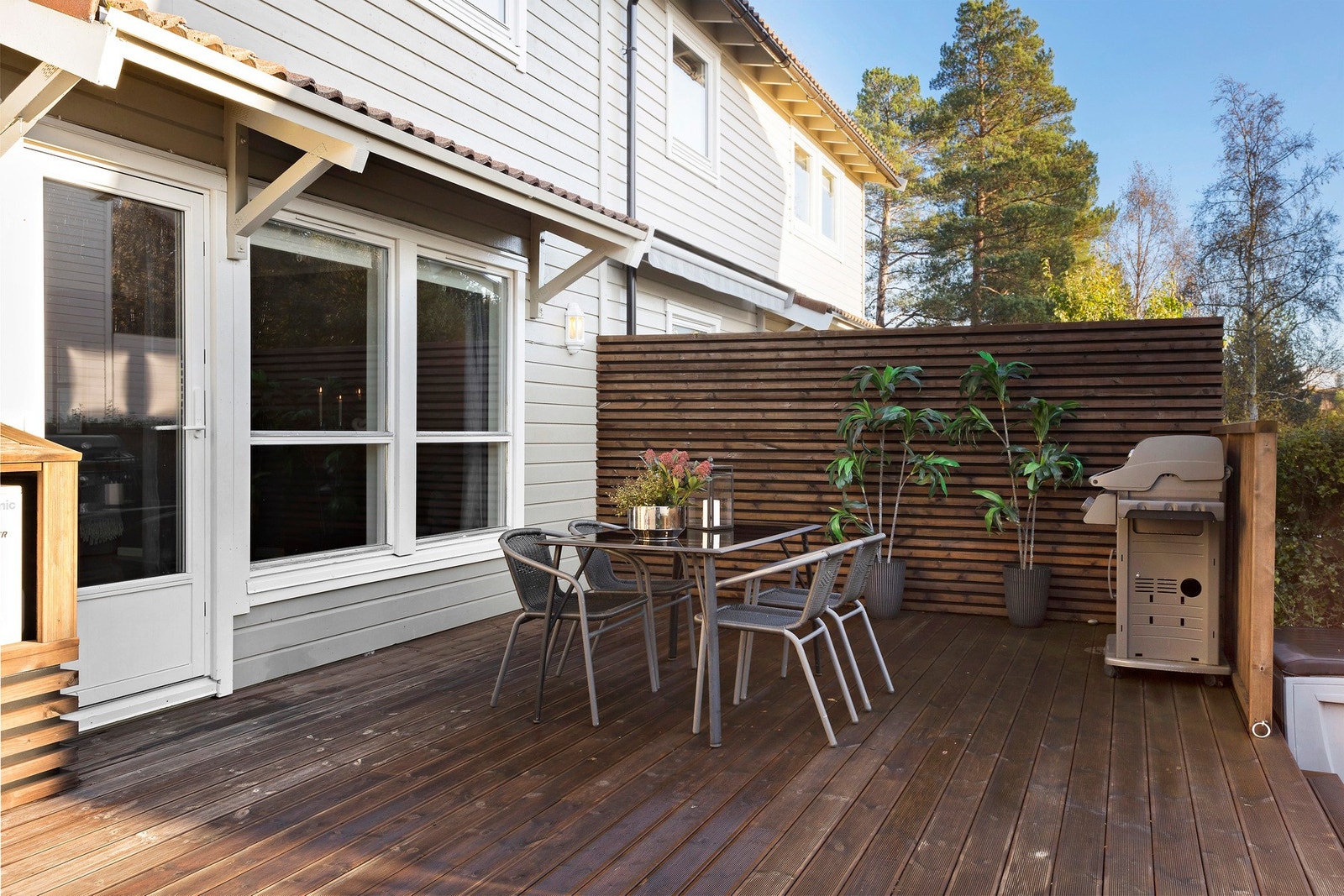 Terrassen er utført i Møre Royal impregnerte rillede terrassebord og er pent skjermet mot naboen med skillevegg og hekk Galleribilde