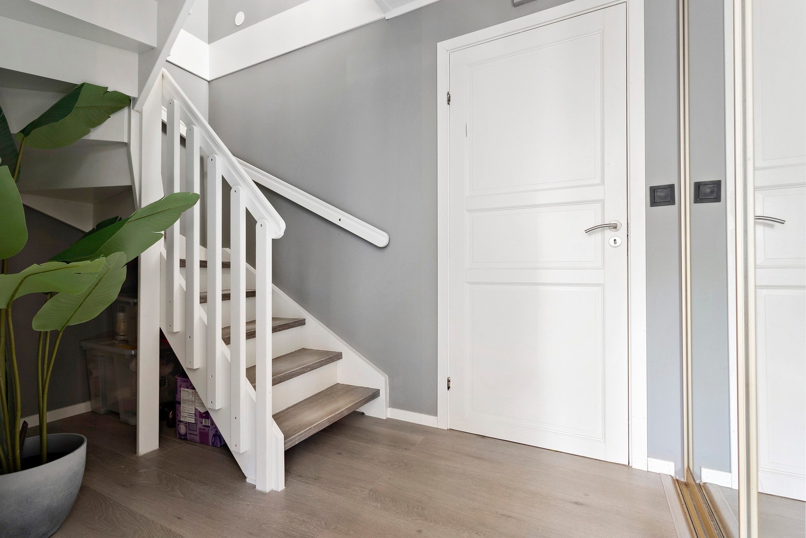 Passende plass til oppbevaring under trapp. Det er også etablert en praktisk skyvedørsgarderobe med speilfronter ved entréen. Galleribilde