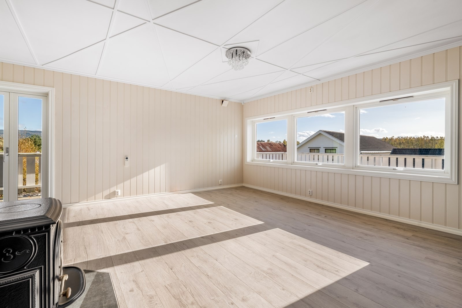 Sentralt i rommet er det etablert ildsted, med peisovn type Jøtul. Pipe og brannmur er kledd i steinpanel. I stuen er det også montert varmepumpe. Galleribilde