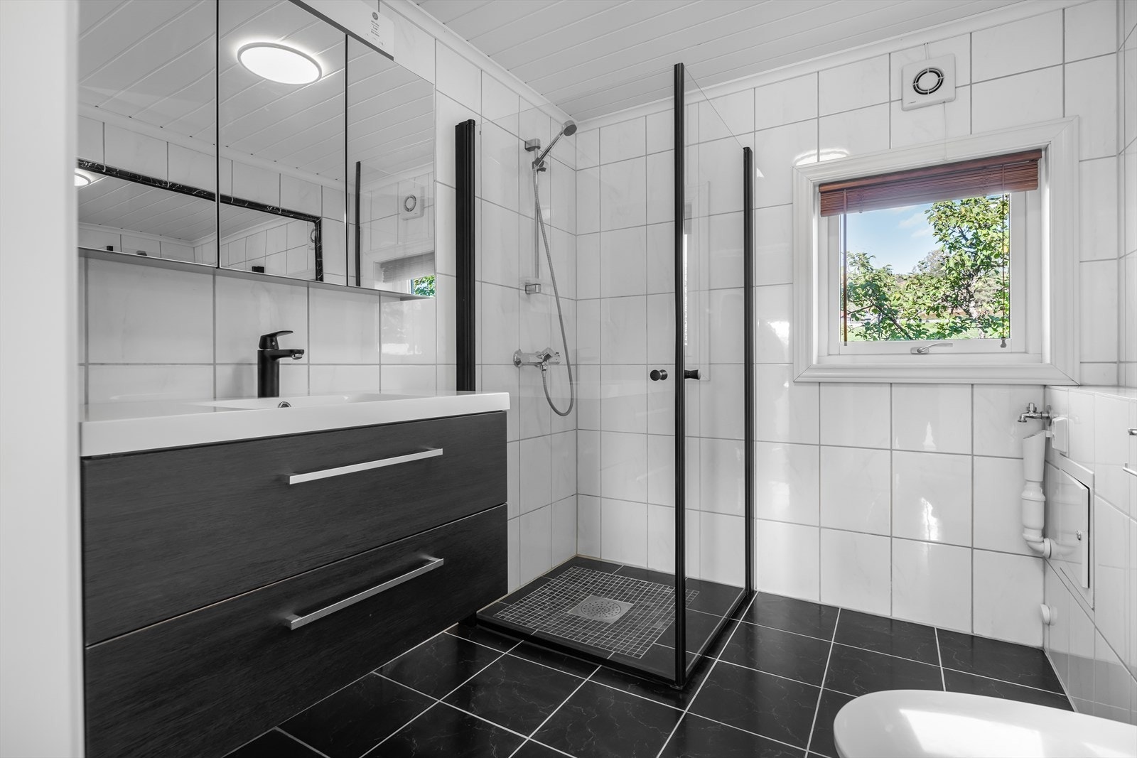 Lyst og pent, flislagt bad i hovedetasjen, pusset opp i 2009. Badet er utstyrt med vegghengt toalett, dusjnisje og opplegg for vaskemaskin. Galleribilde