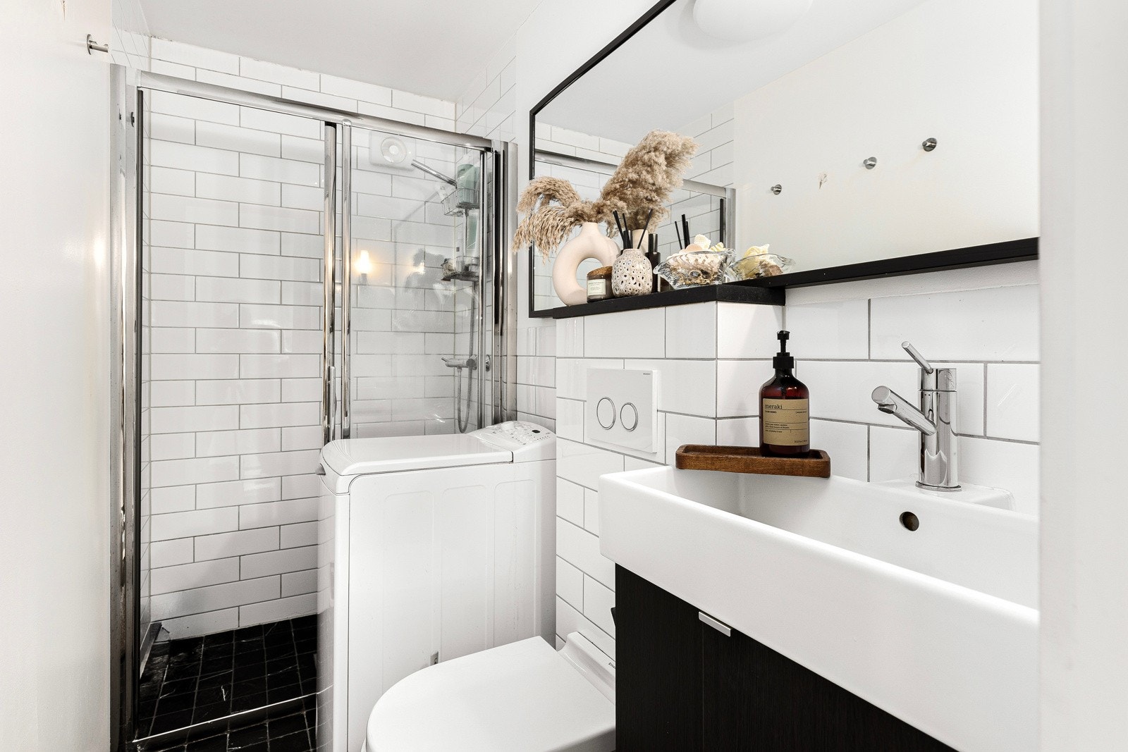 Tidløst, flislagt baderom i hybeldel med varmekabler i gulv, romslig dusjsone og pen innredning. Galleribilde