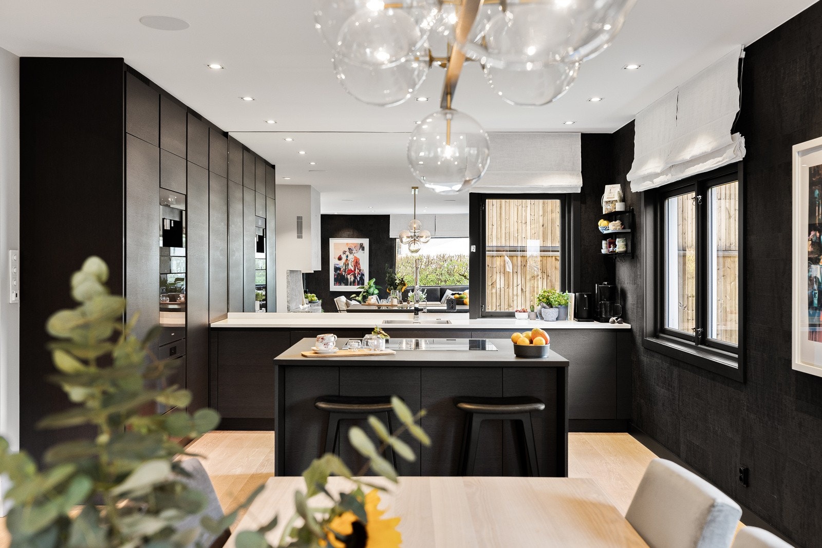 Boligen har en åpen kjøkkenløsning mot stuen/spisetue med stor kjøkkeninnredning som strekker seg over to hele vegger med helintegrerte, eksklusive hvitevarer fra Miele og romslig kjøkkenøy. Galleribilde