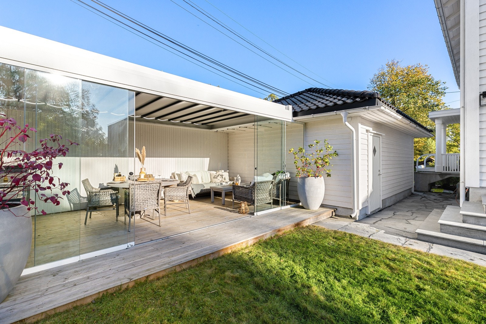 Stilig pergola med skyvedører av glass og lamelltak som kan åpnes og lukkes etter værforholdene. Galleribilde