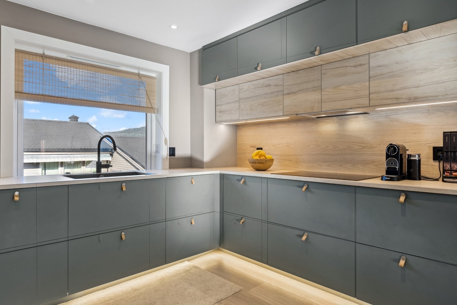 IKEA innredning fra 2021 med grønne glatte fronter, laminert benkeplate og nedfelt sort oppvaskkum i kompositt med ett-greps armatur. Galleribilde