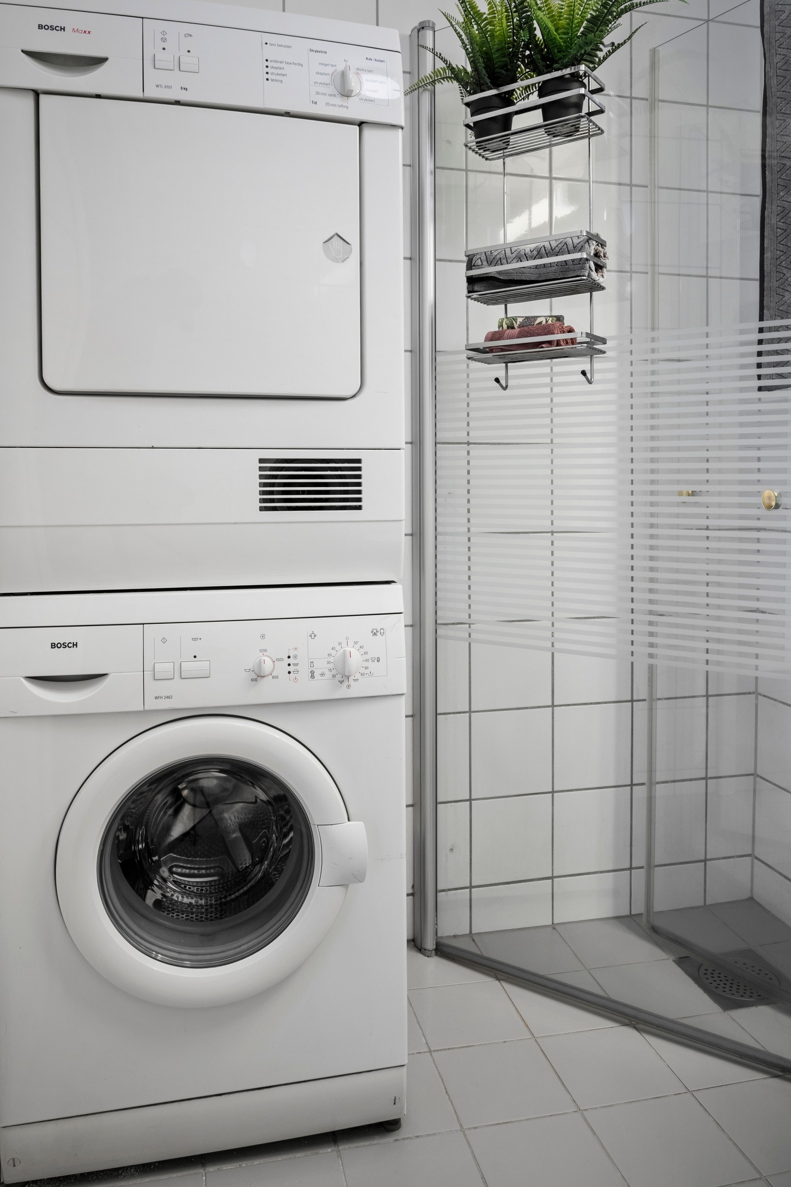 Badet er utstyrt med dusj med innfellbare glassvegger, servant med skap, innmurt speil med lys, gulvmontert wc og opplegg for vaskemaskin/tørketrommel. Galleribilde