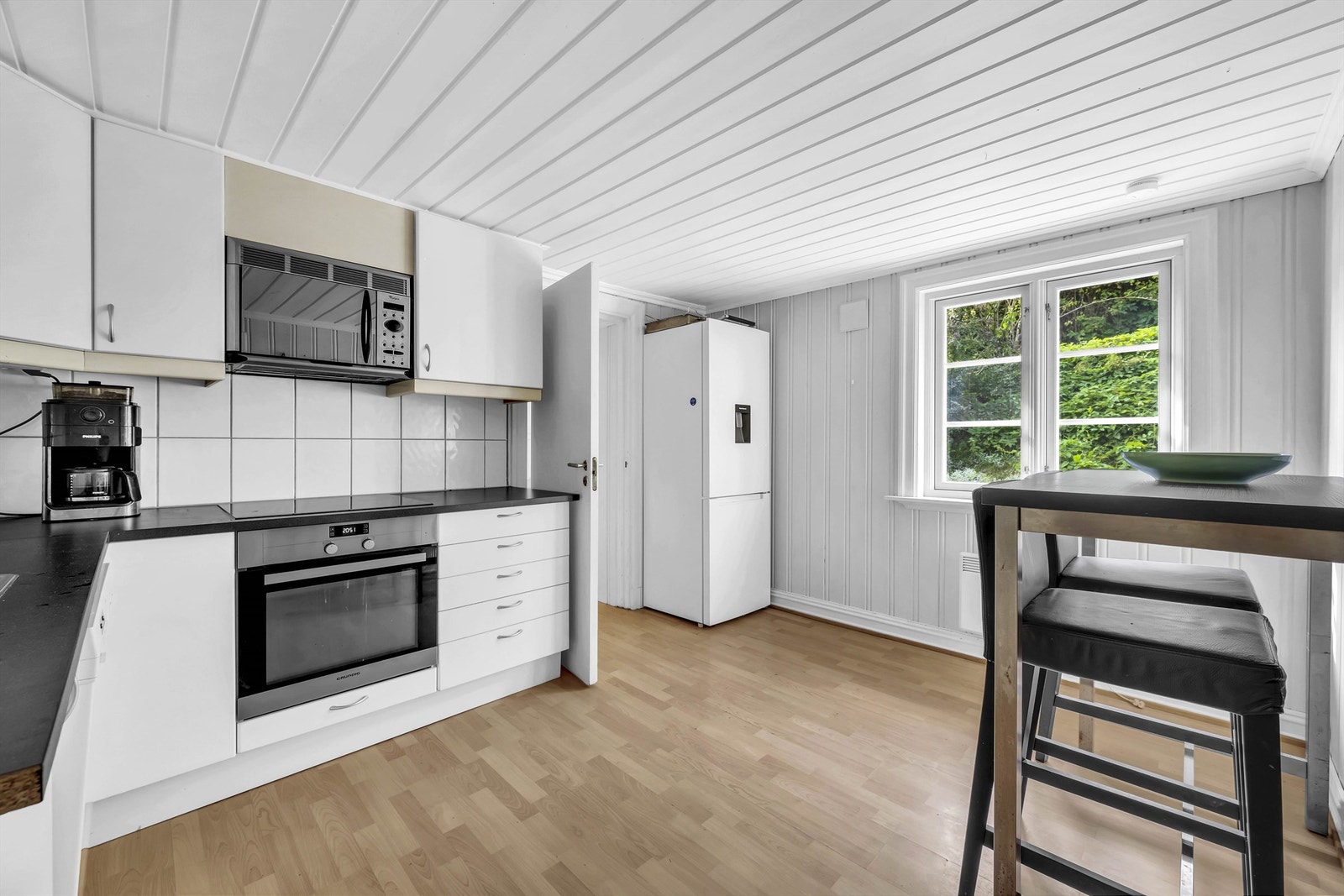 Pent innredet kjøkken med plass til spisebord. Ventilator, induksjonstopp,
mikrobølgeovn og stekeovn er integrert i innredningen Galleribilde