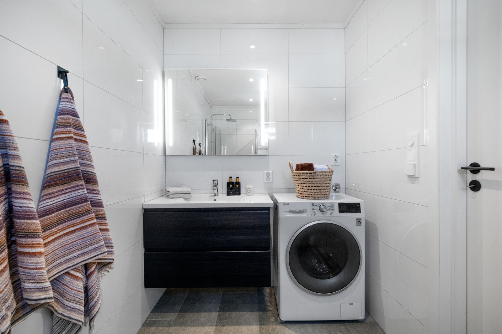 Badet har dusjhjørne, toalett, opplegg for vaskemaskin og baderomsinnredning med heldekkende servant. Galleribilde