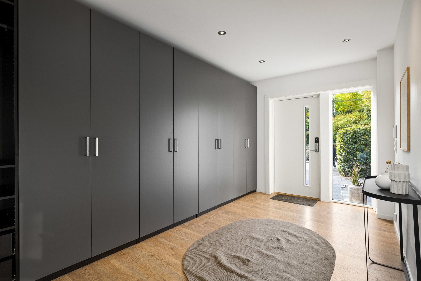 Entréen i første etasje er romslig. Entréen har et stort garderobeskap til oppbevaring av familiens yttertøy, sko og annet. Her er det laminat på gulvet, og veggene er holdt i lyse toner. I gulvet er det elektriske varmekabler. Galleribilde