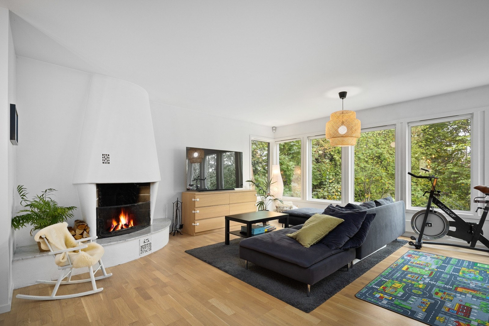 Etasjen har en åpen og luftig stue løsning. Stuen har store vindusflater som gir godt med lys til rommet. Rommet er holdt i lyse toner. Stuen har en stor flott peis, som bidrar til både hygge og varme. Galleribilde