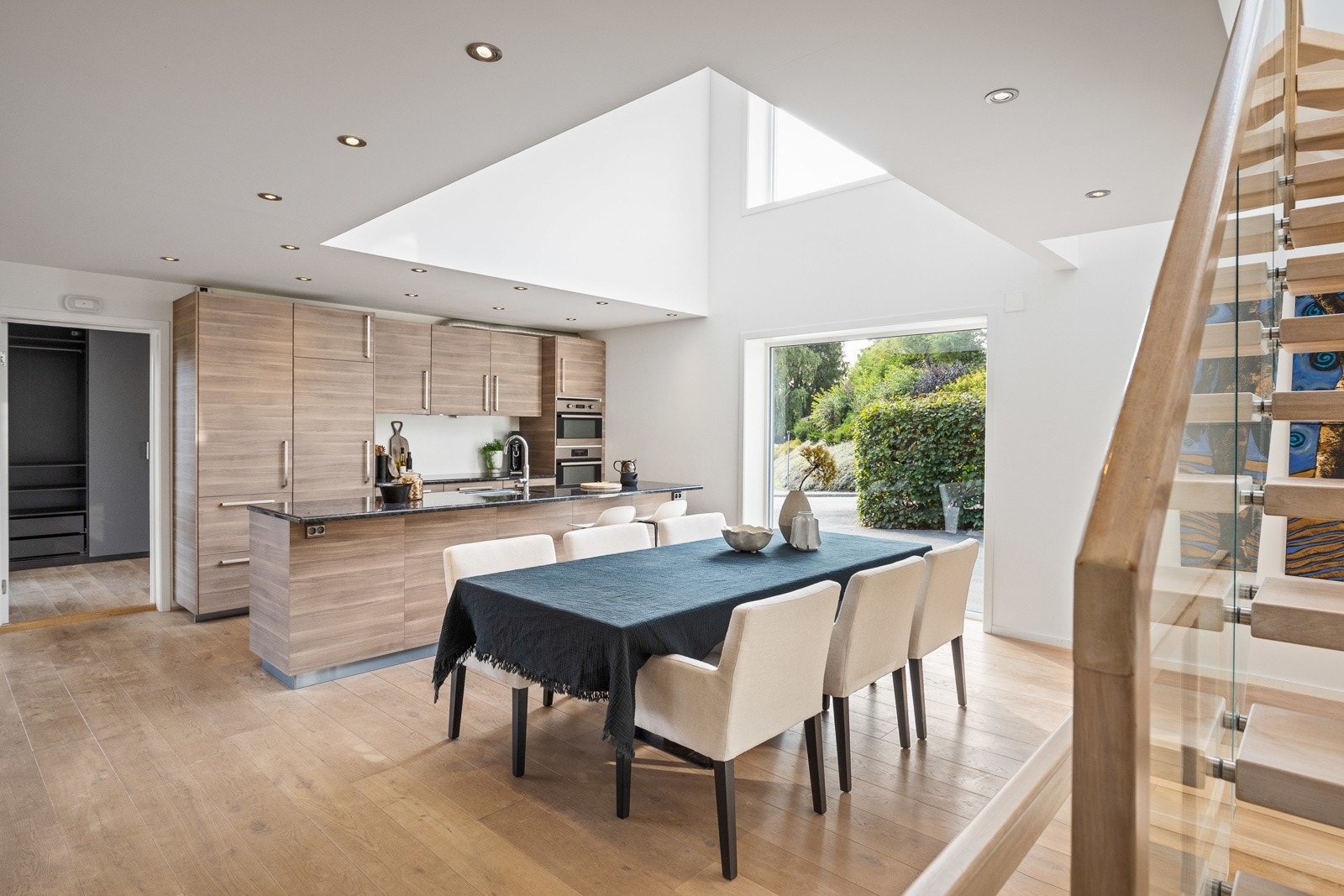 Kjøkkenet ligger i åpen løsning til stuen, noe som gjør at du som vert også kan delta i de sosiale samtalene under matlagingen. Kjøkkenet har masse oppbevaringsmuligheter i benkeskap og overskap med slette fronter. Benkeplate av stein. Galleribilde