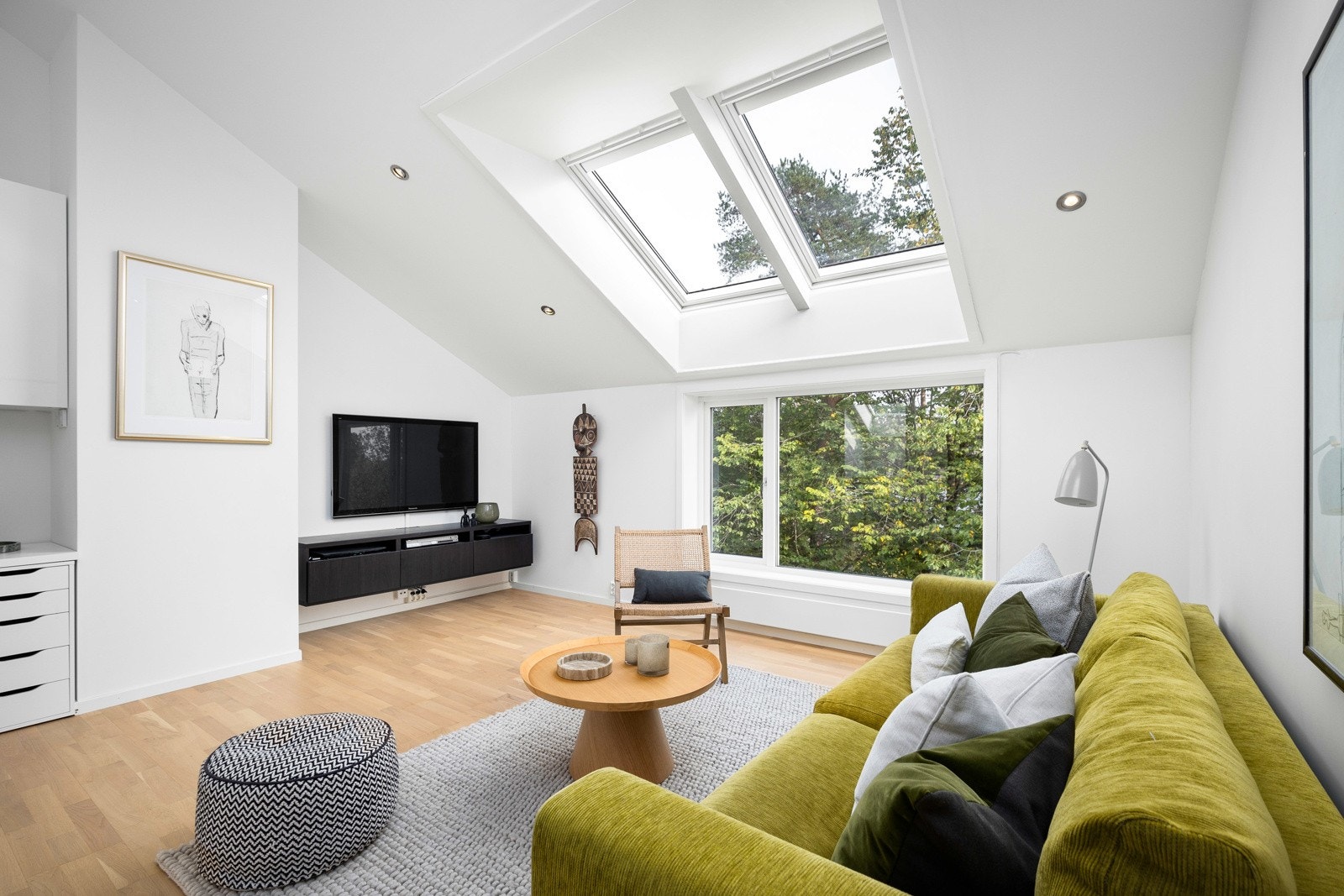 Loftstuen er åpen og luftig, med store vindusflater som slipper inn godt med lys og inviterer naturen utenfor inn. Galleribilde