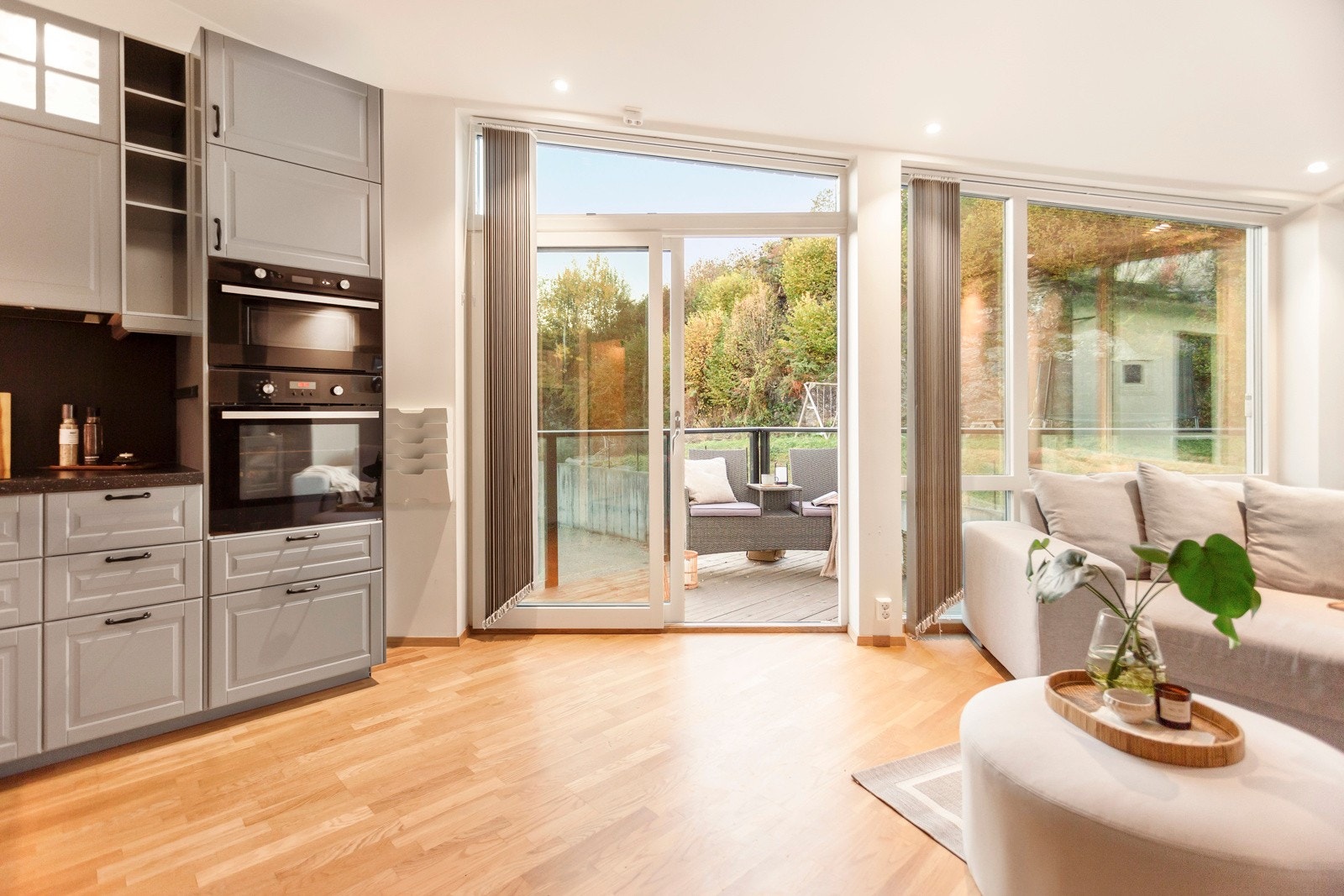 Lys og luftig stue med mye lysinnslipp gjennom de store vinduene Galleribilde