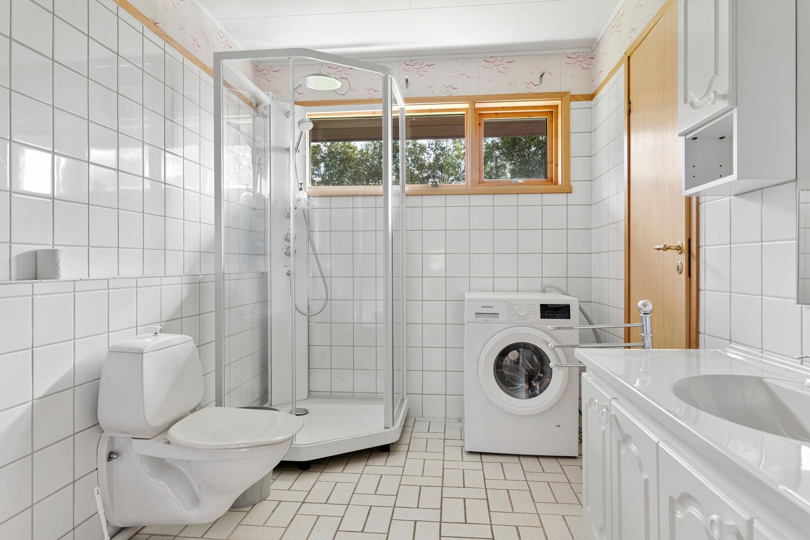 Flislagt bad fra 1983, innredet med servant, toalett, dusjkabinett og opplegg for vaskemaskin. Galleribilde