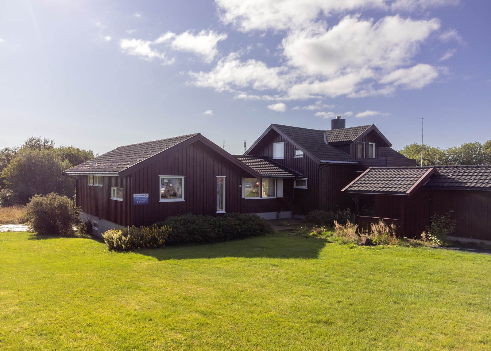 Boligen har en pent opparbeidet hage med stor plen, trær og beplantning. Galleribilde